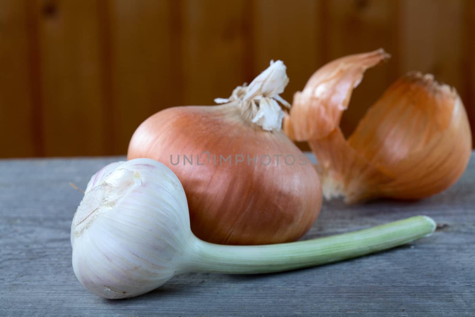  garlic onions and peel on a table from unplaned boards