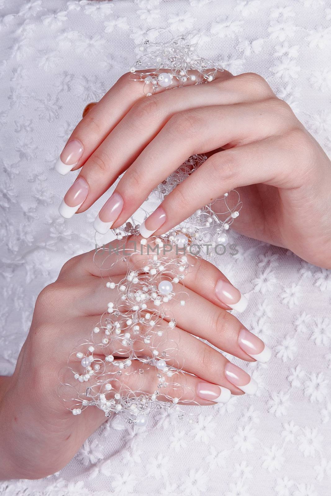 Beautiful female hands with manicure against a white dress