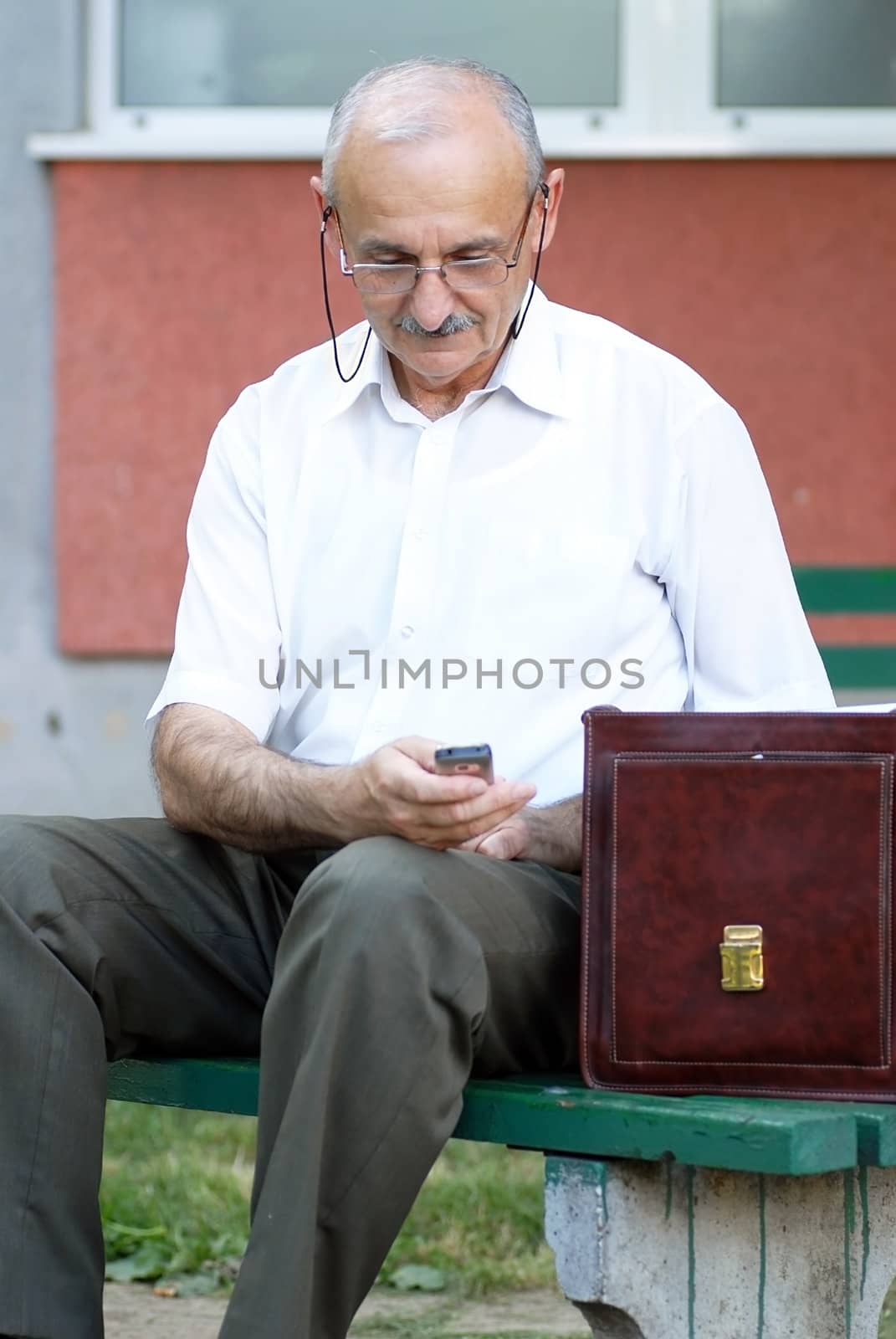 portrait of caucasian mature man in glasses with a mobile phone
