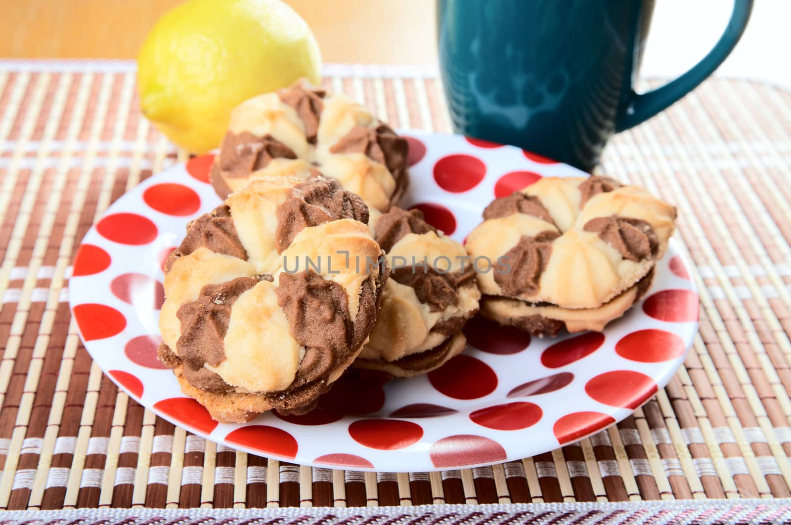 Cookies on a plate with  cup and  lemon