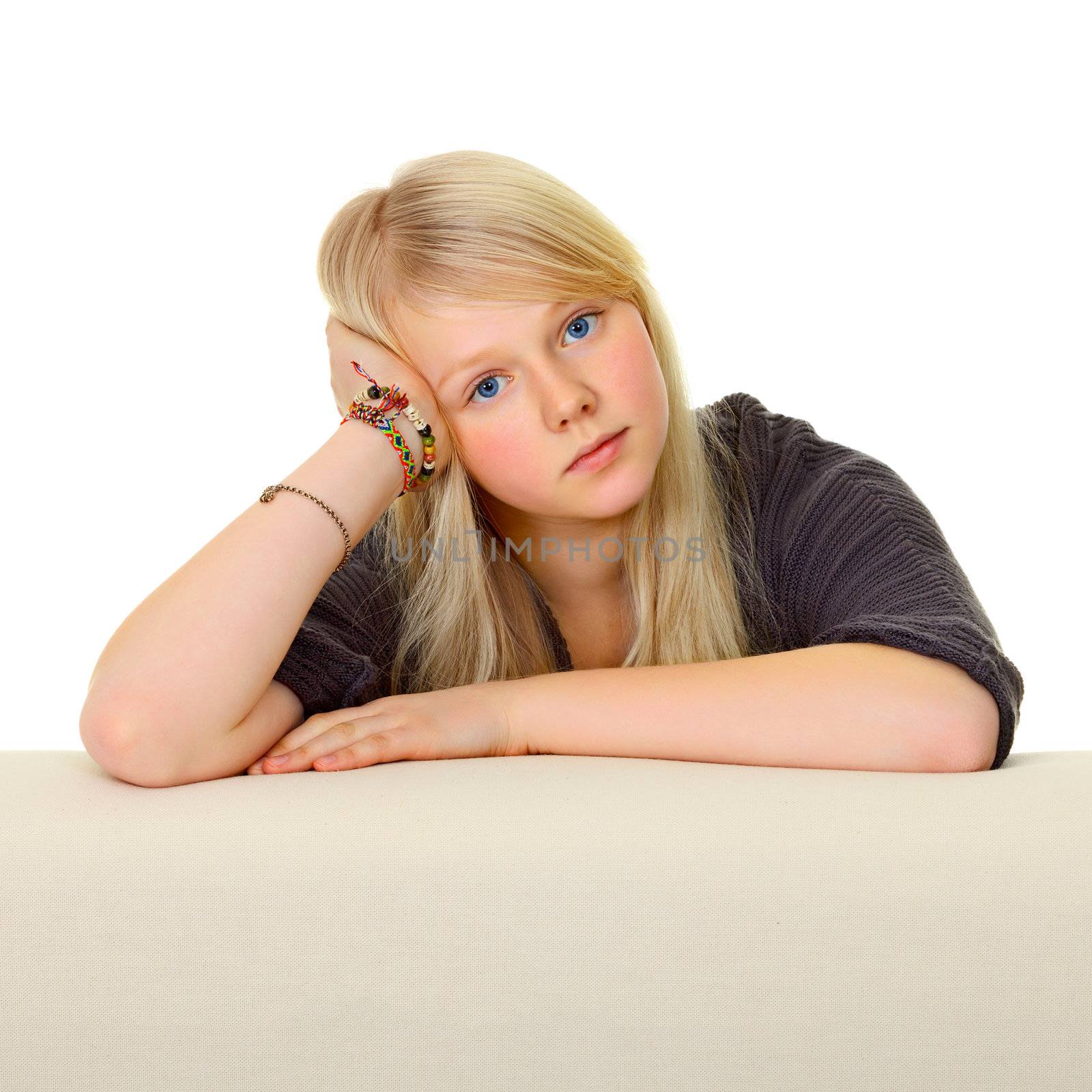 The young girl leans on back of the sofa