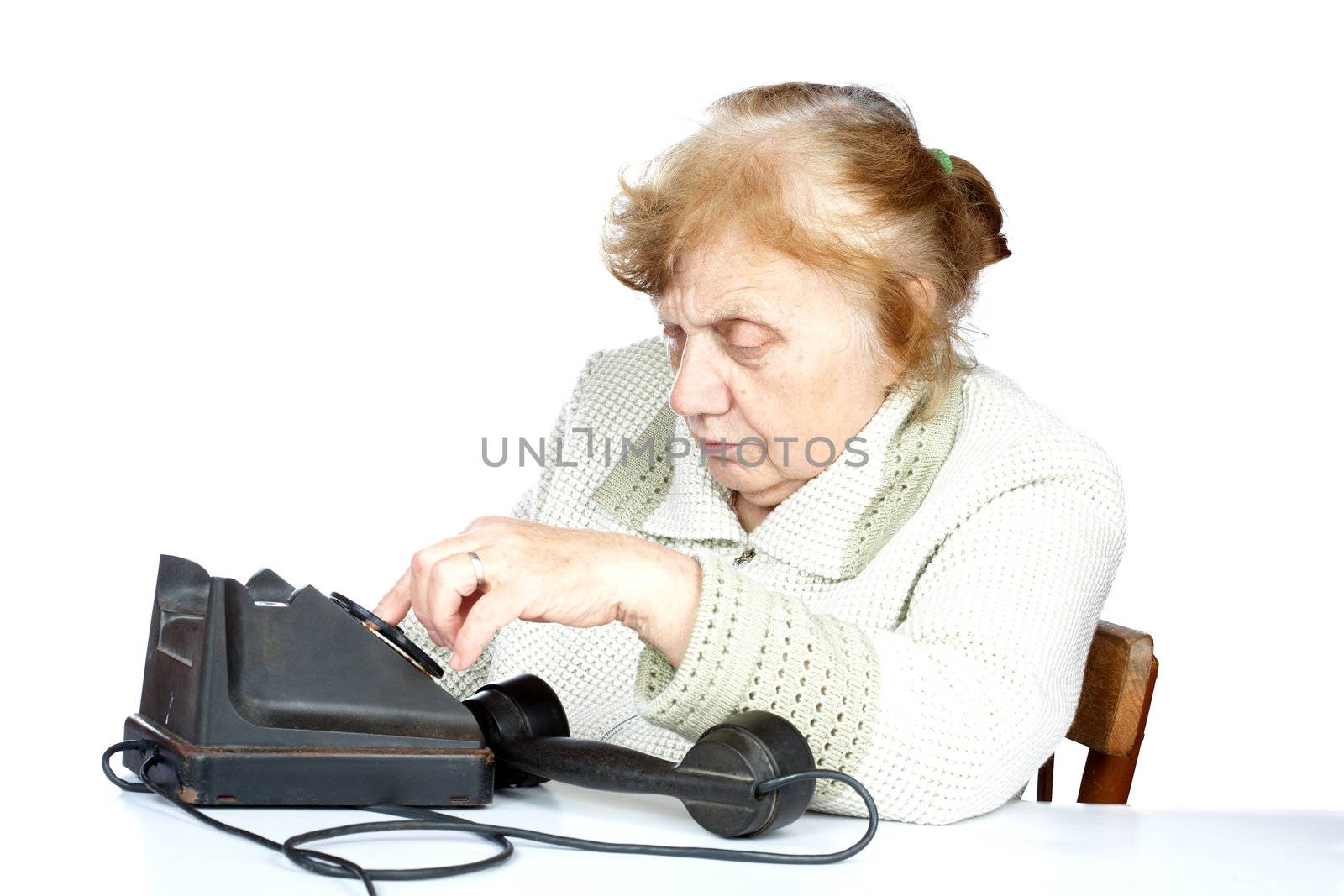 The old woman dials  number of phone on a white background