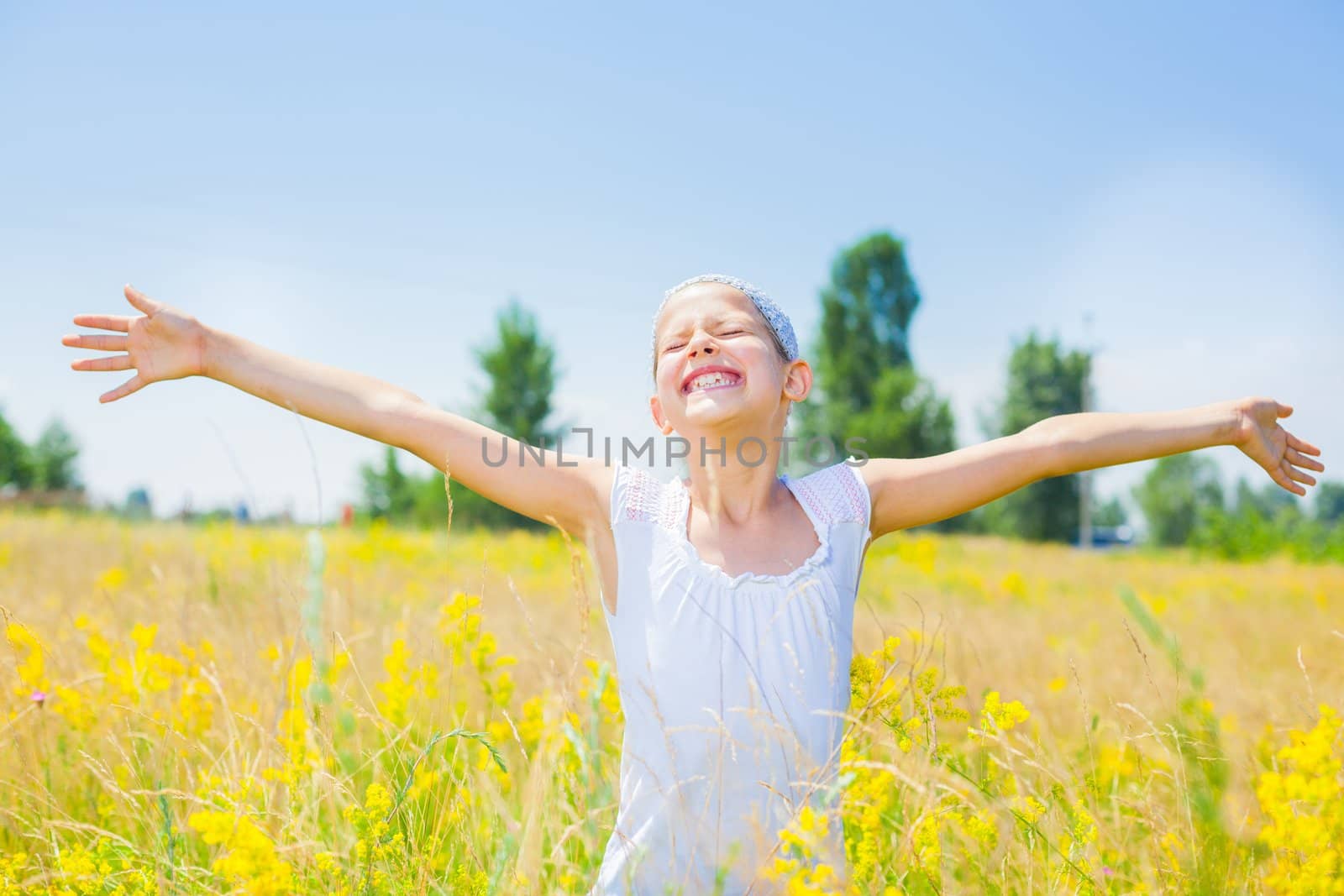 Adorable happy girl in yellow flowers field. Summer freedom andjoy concept.