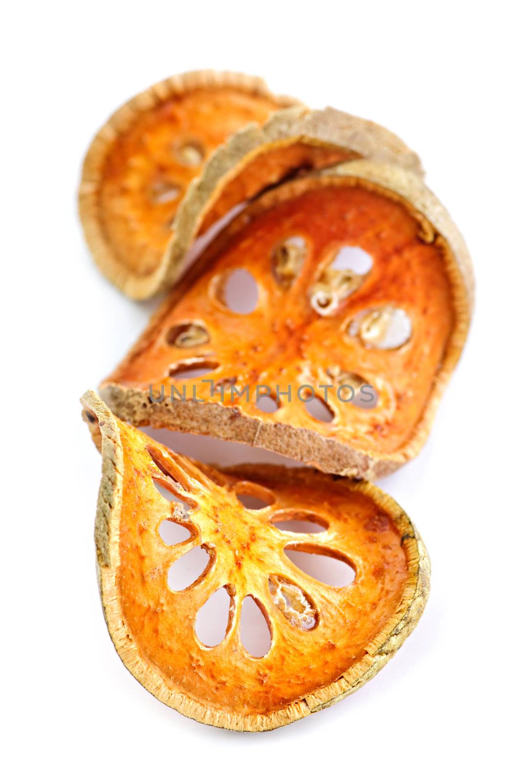 Slices of dried bael fruit on white background