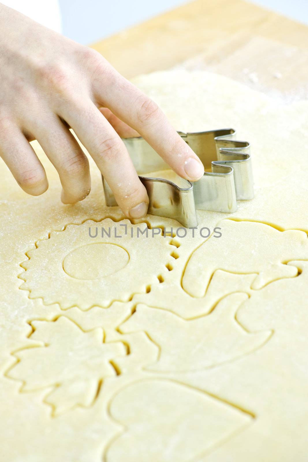 Cutting cookie shapes in rolled dough with cutter