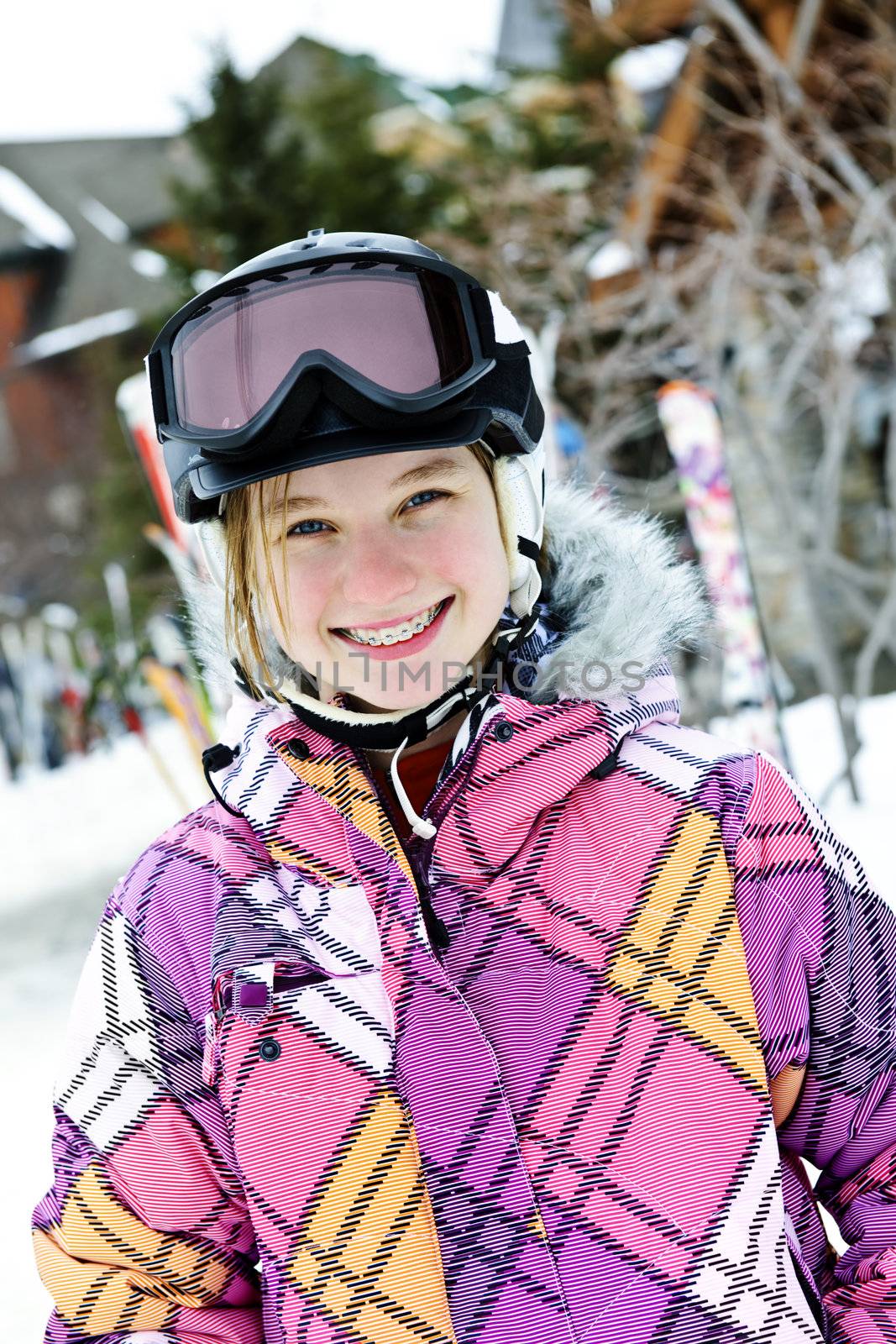 Happy girl in ski helmet at winter resort by elenathewise