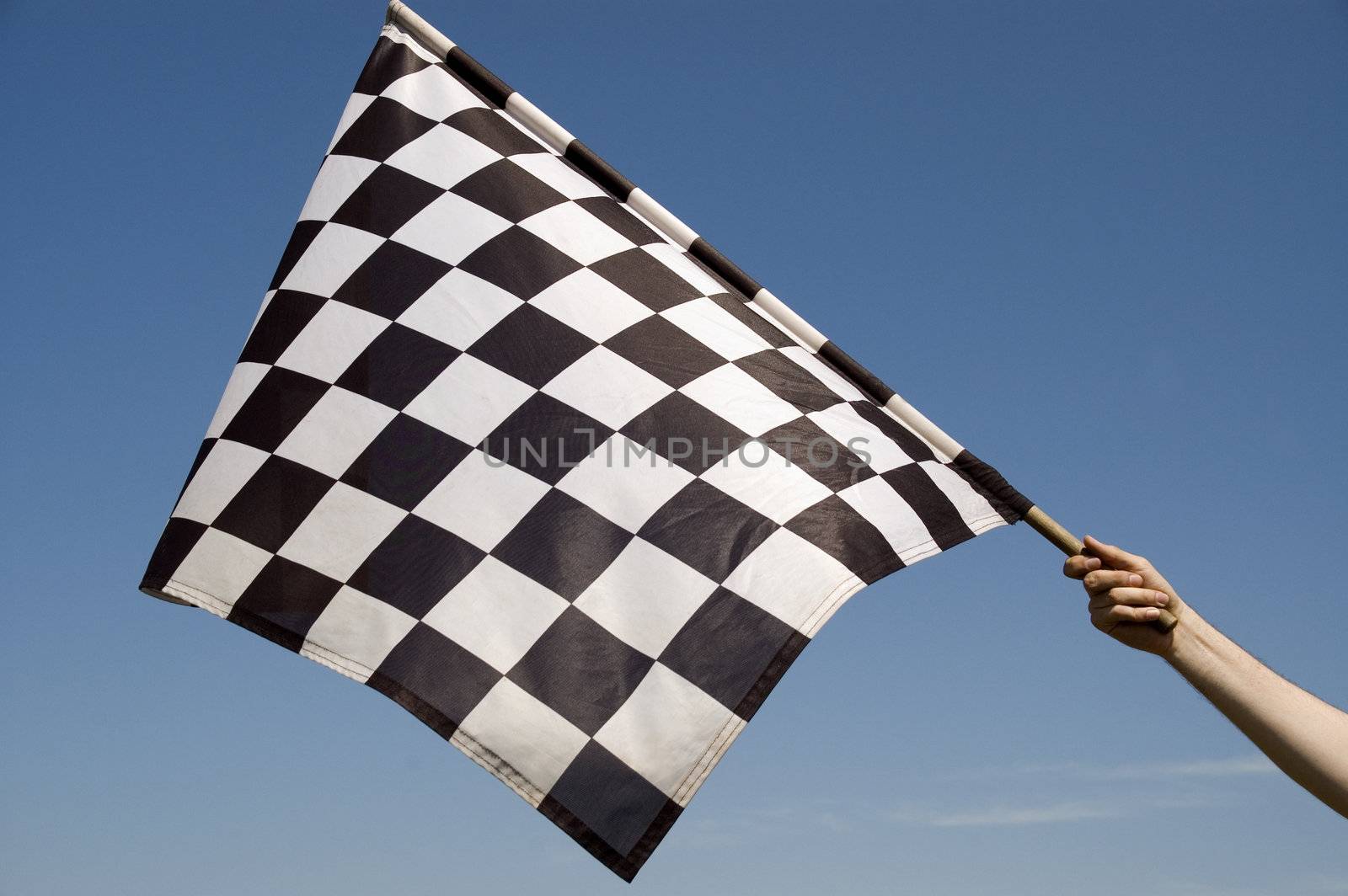 Auto racing checkered flag on a background of the  blue sky.