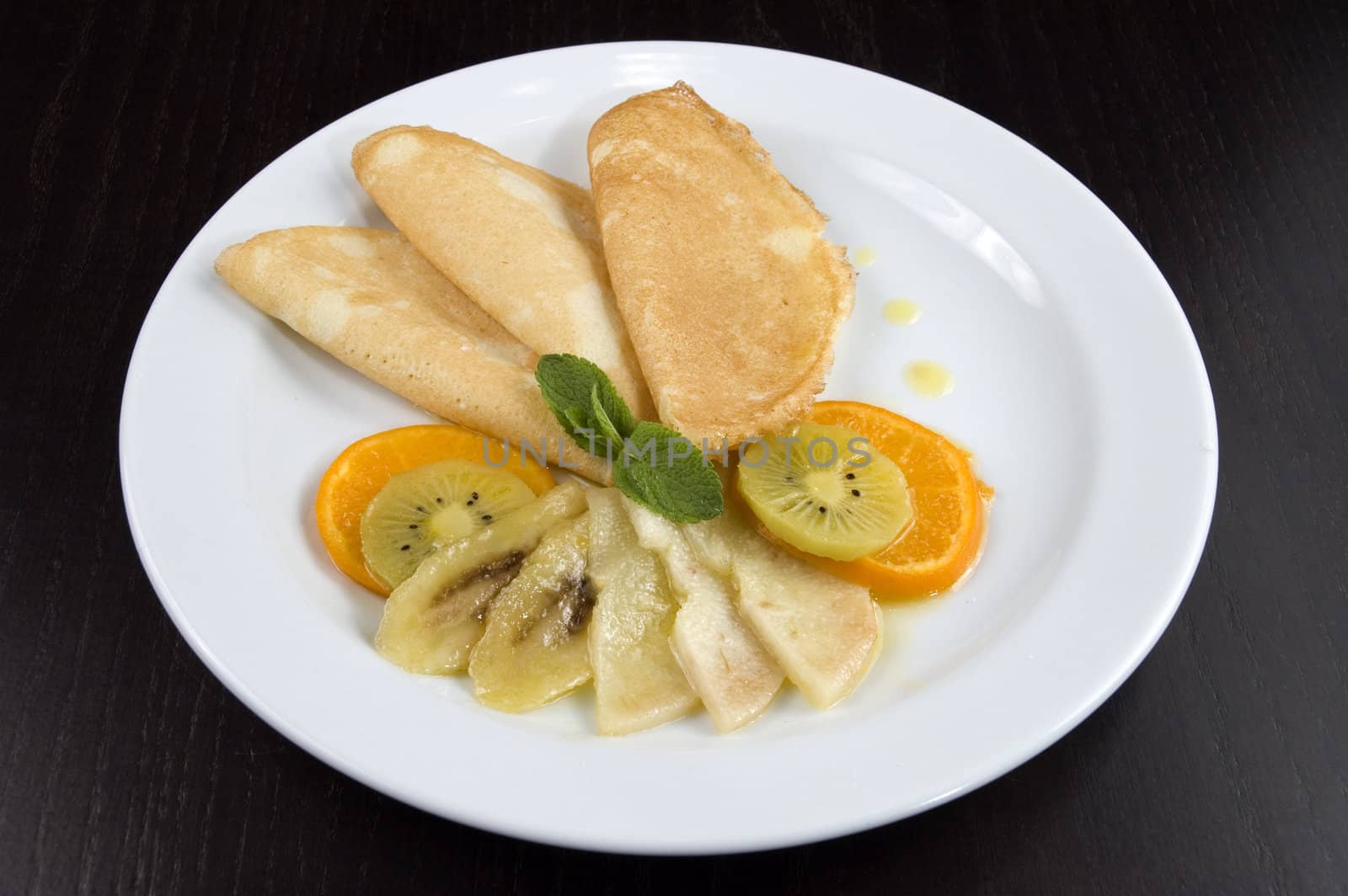 Pancakes with fruit on a white plate.