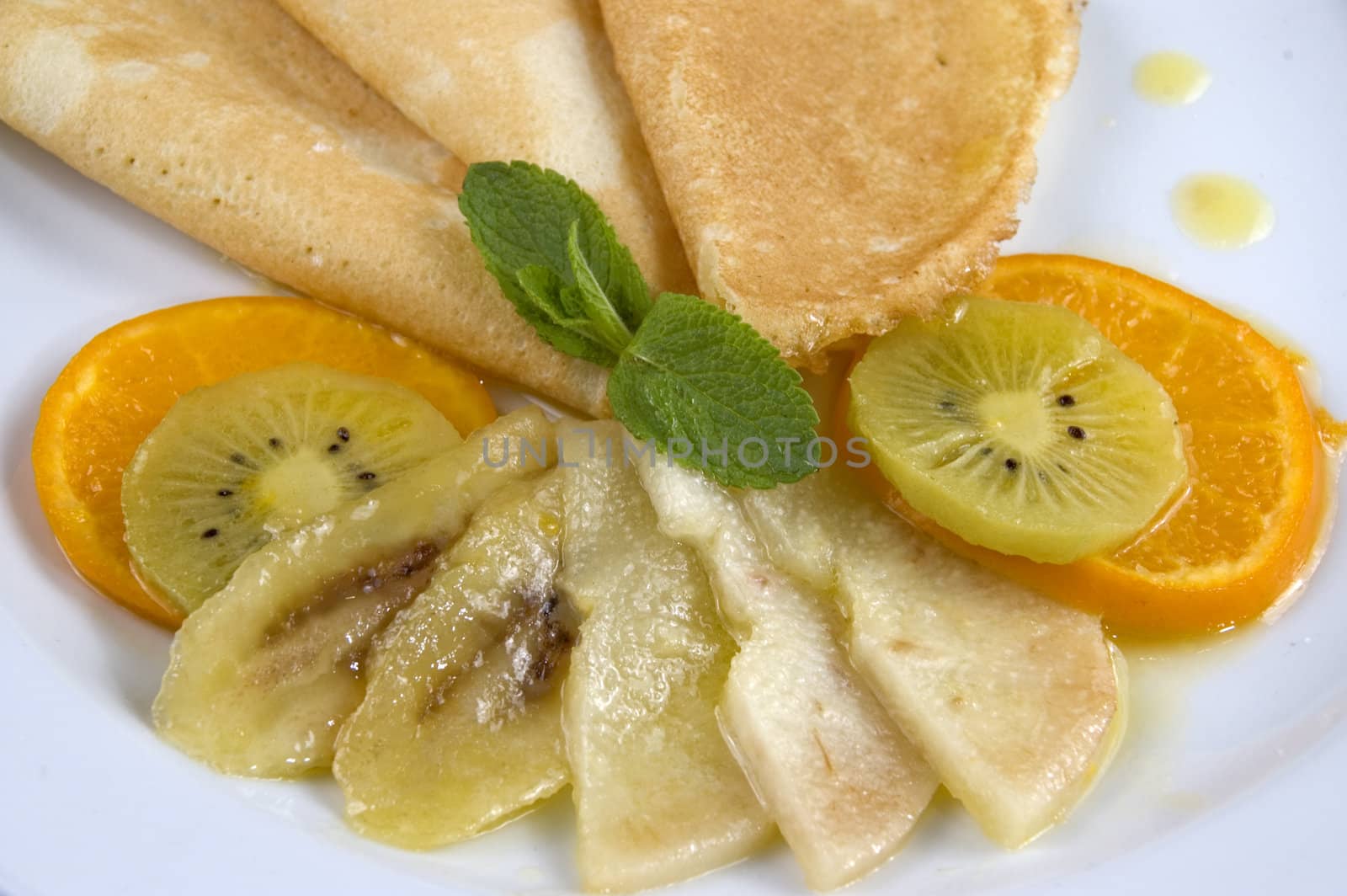 Pancakes with fruit on a white plate.