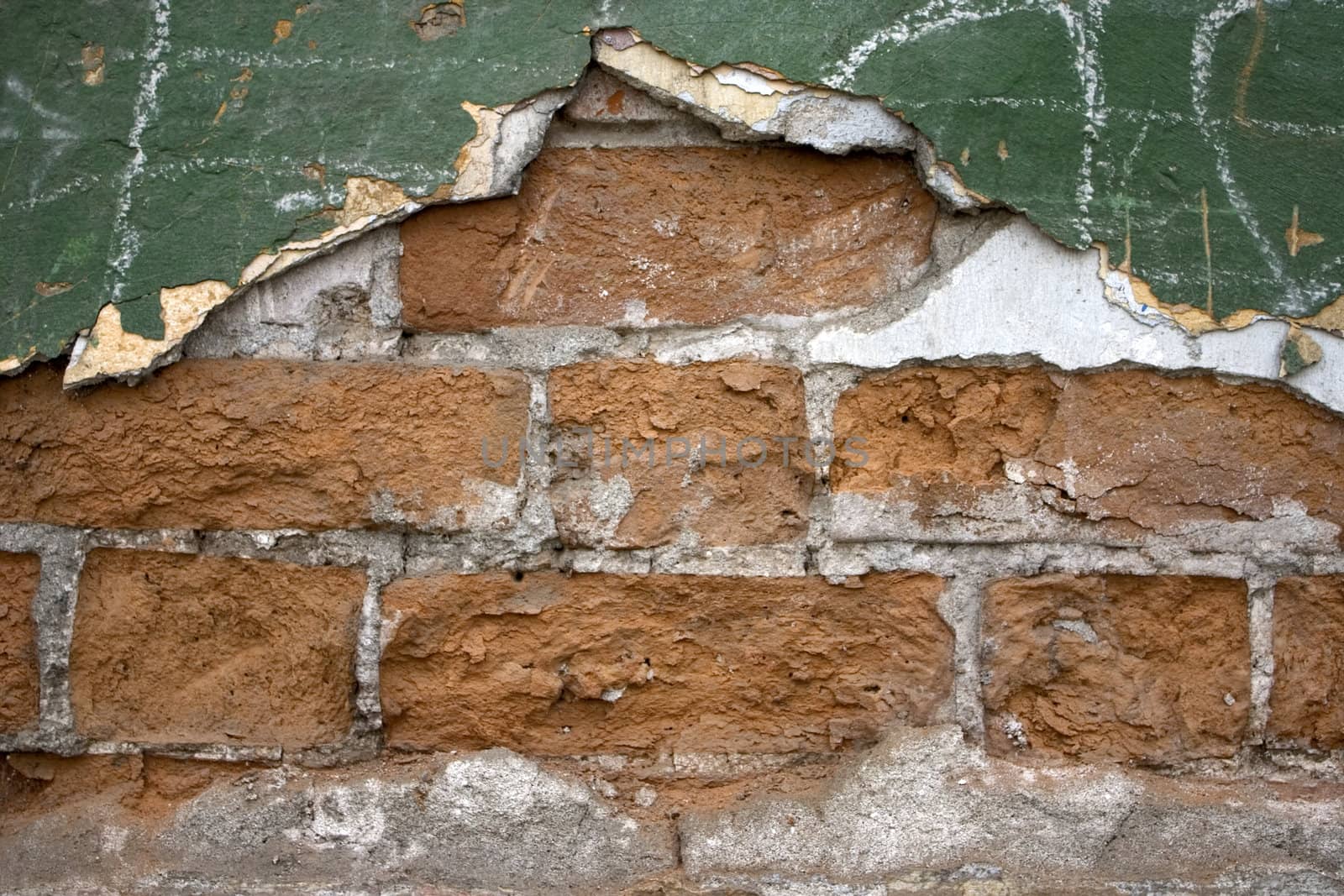 Old wall from a red brick. Green paint.