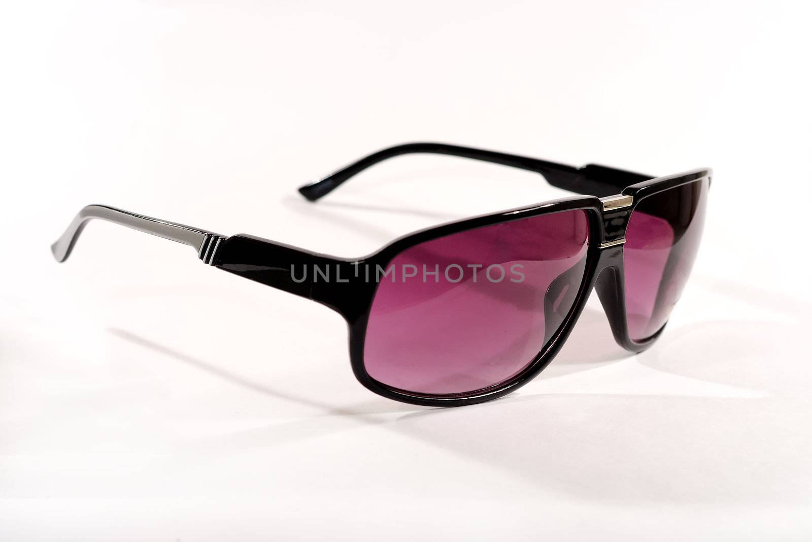 Pair of fashionable modern sunglasses with graduated polarised lenses on a white background