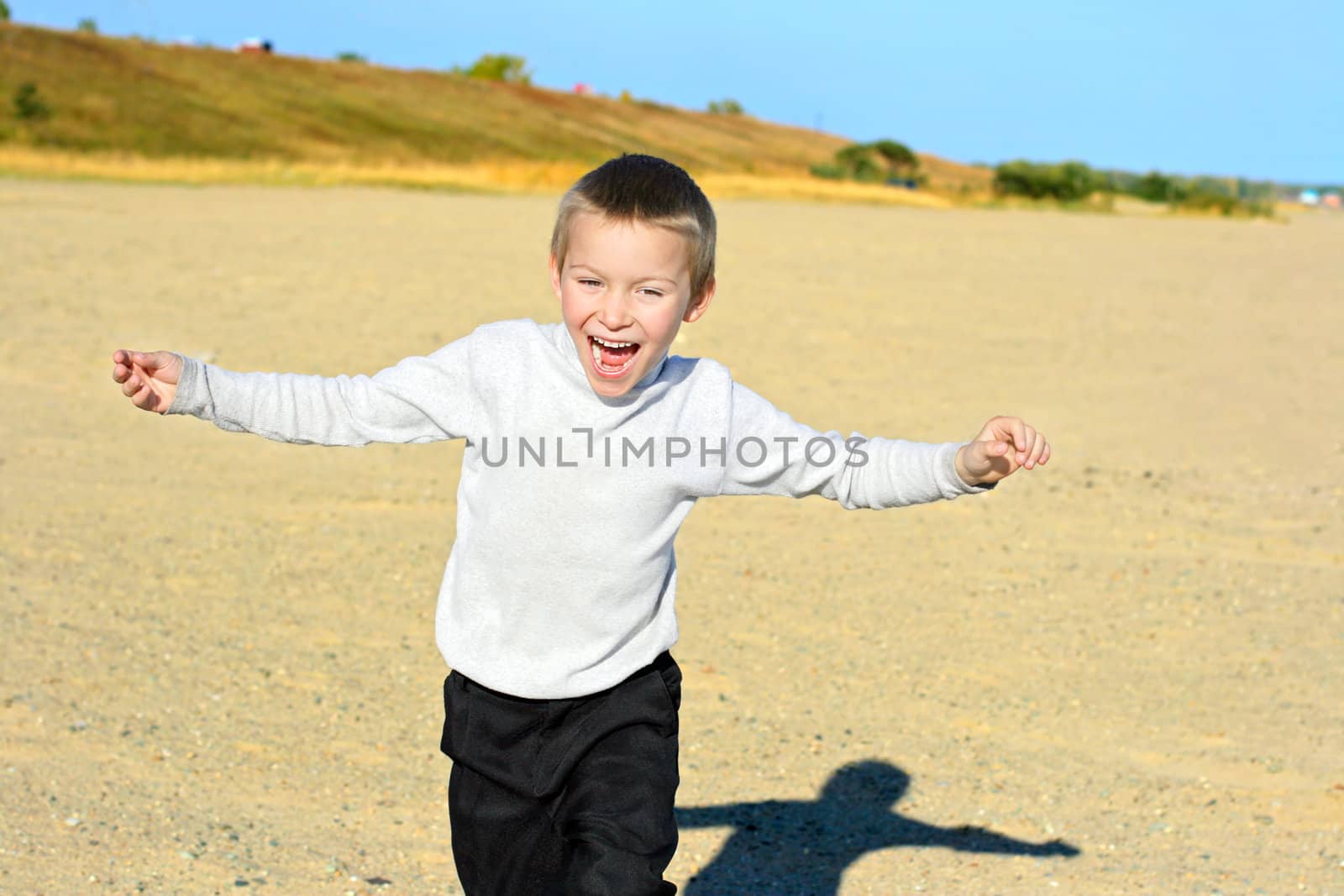 happy boy running on the empty beach