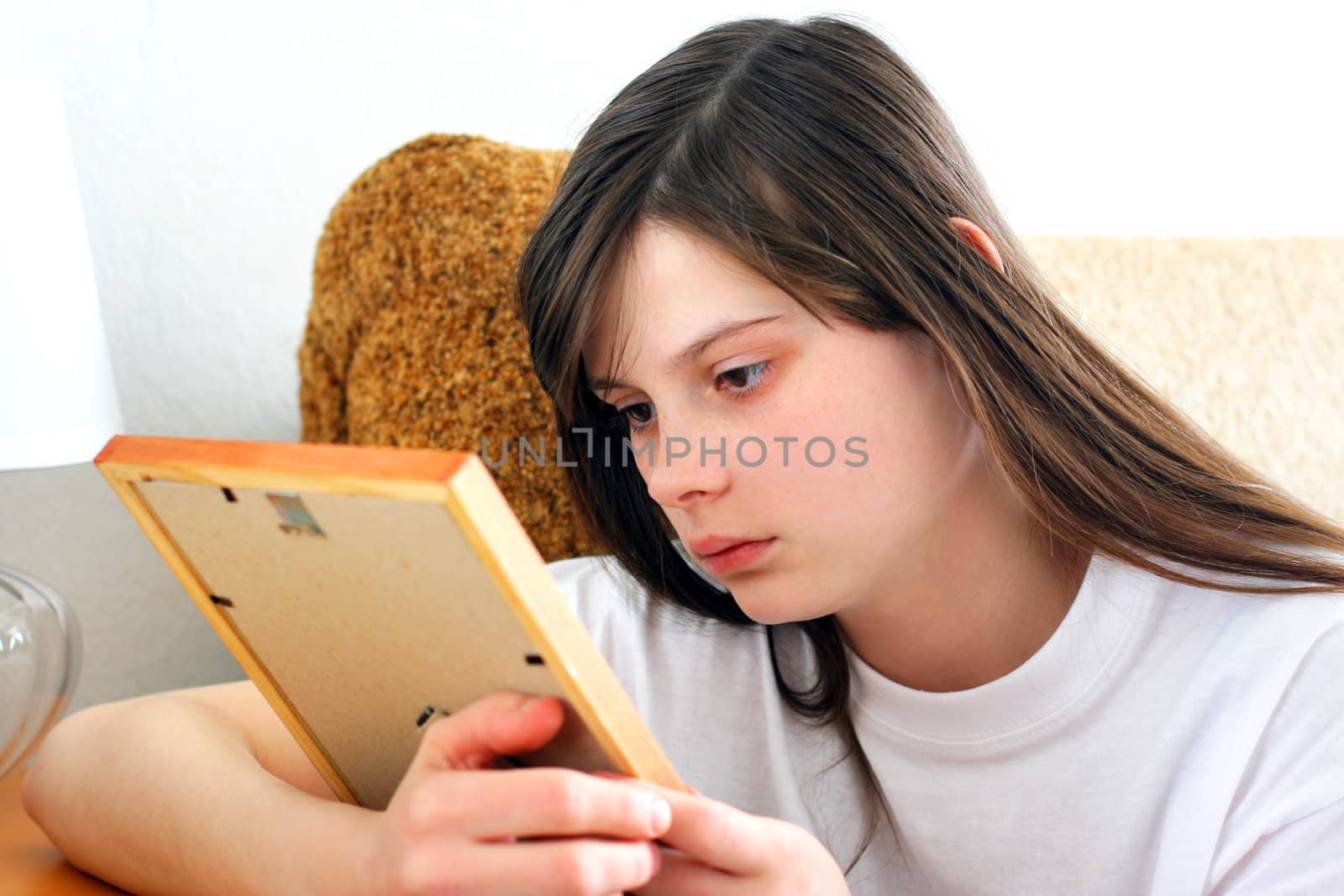 Sad Teenage Girl looking on the photo frame