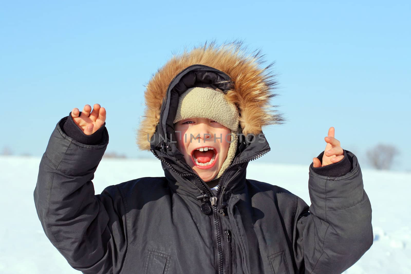 Happy Boy with Hands up in the Winter field