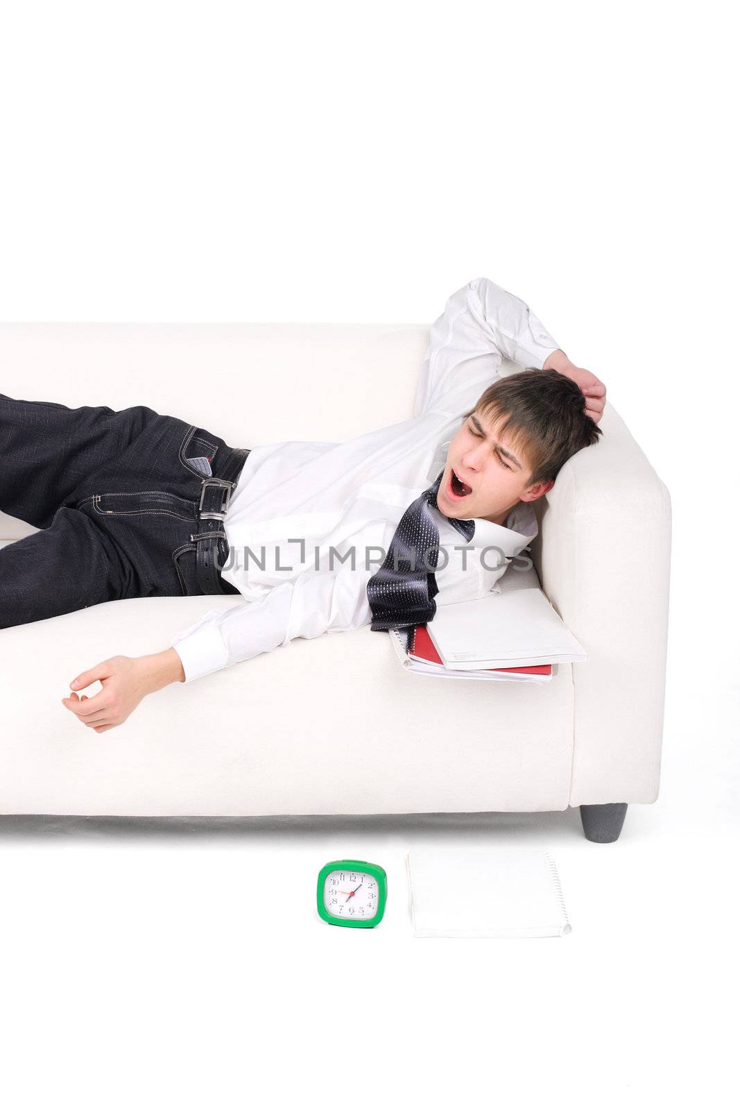 Student waking up on the Sofa with the Books and Alarm Clock. Isolated on the white