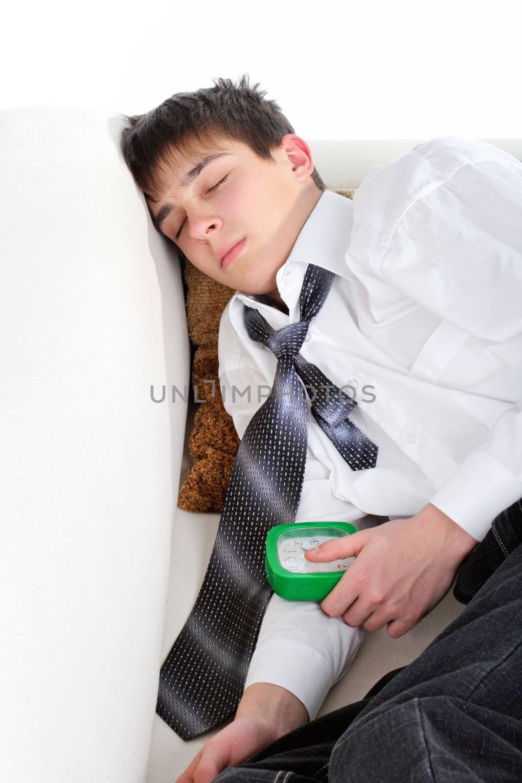 Student sleeping on the Sofa with the Books and Alarm Clock