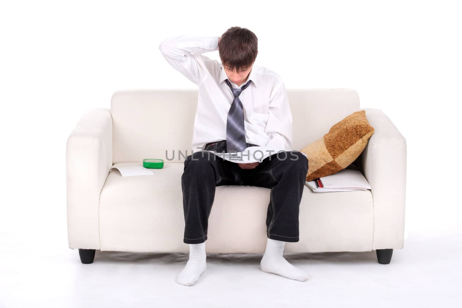 Teenager reads the book on the Sofa. Isolated on the white