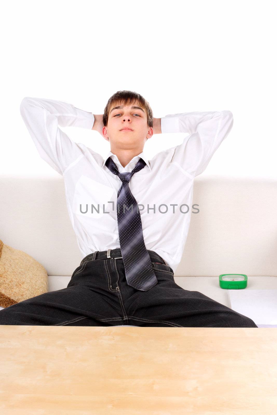 Satisfied Tennager resting on the Sofa. Isolated on the white