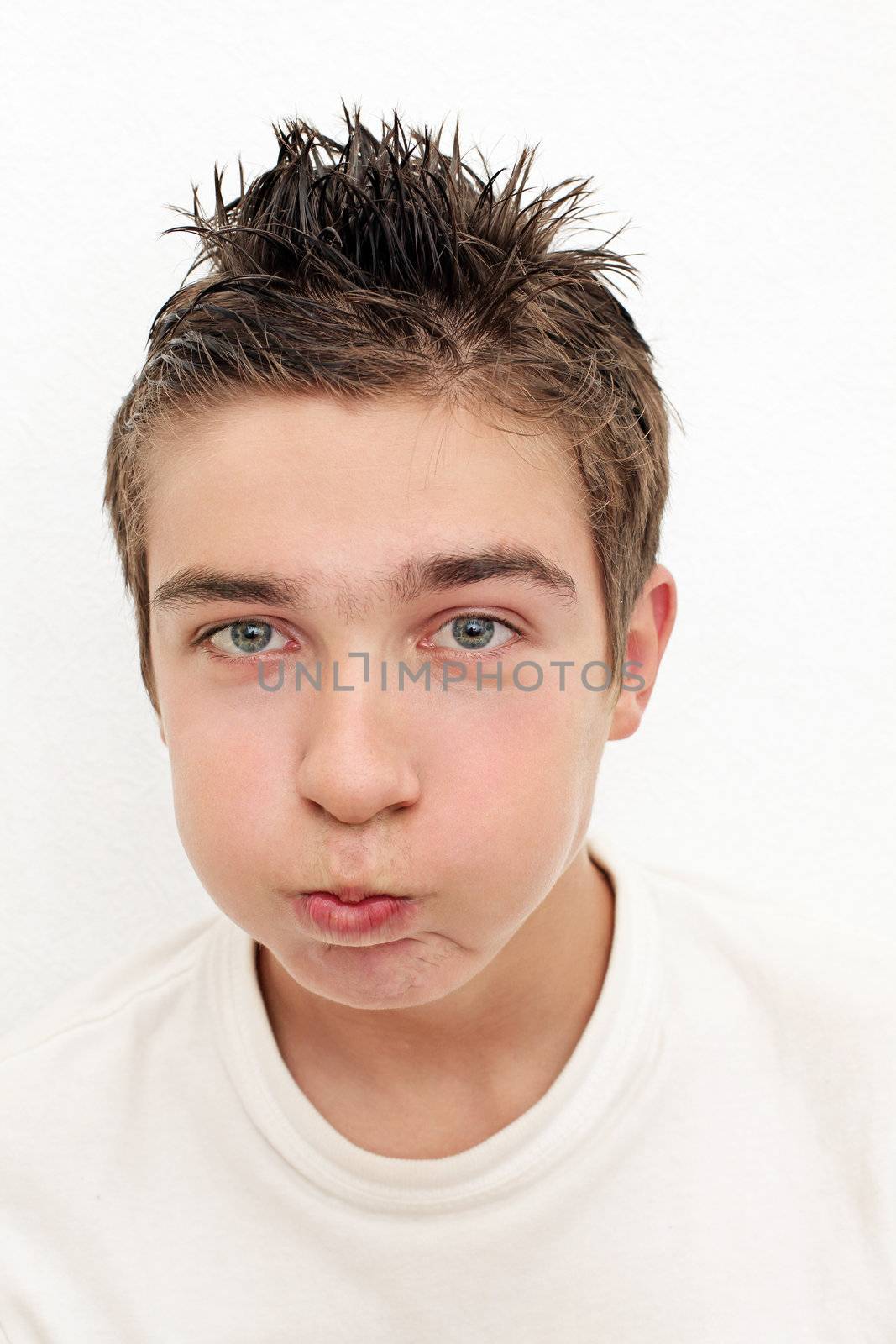 Funny Teenager inflate his cheeks on the White Wall background