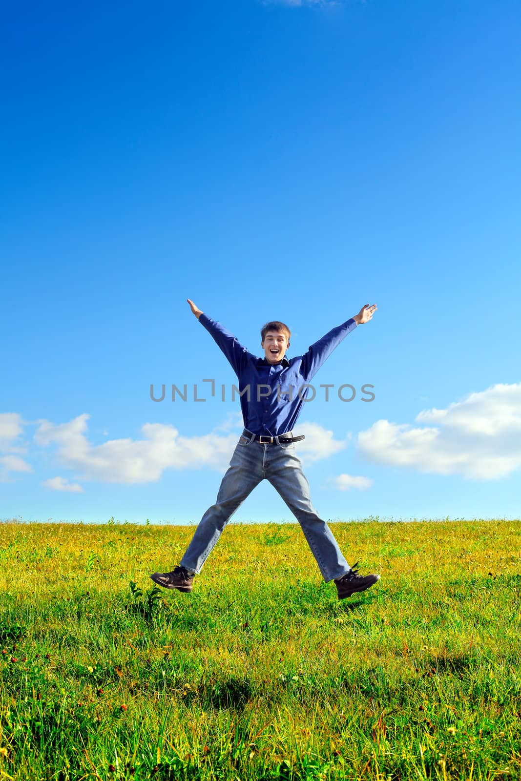 Happy Young Man Jumping in the Summer Field