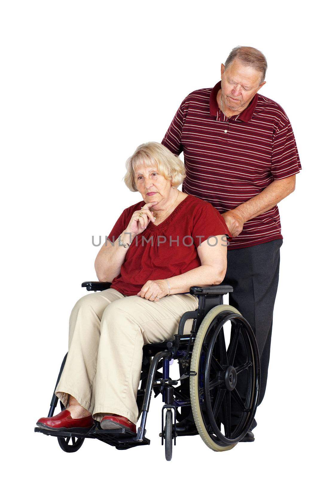 Elderly or senior couple with man caring for his wife in a wheelchair, looking sad or depressed, studio shot isolated over white background.