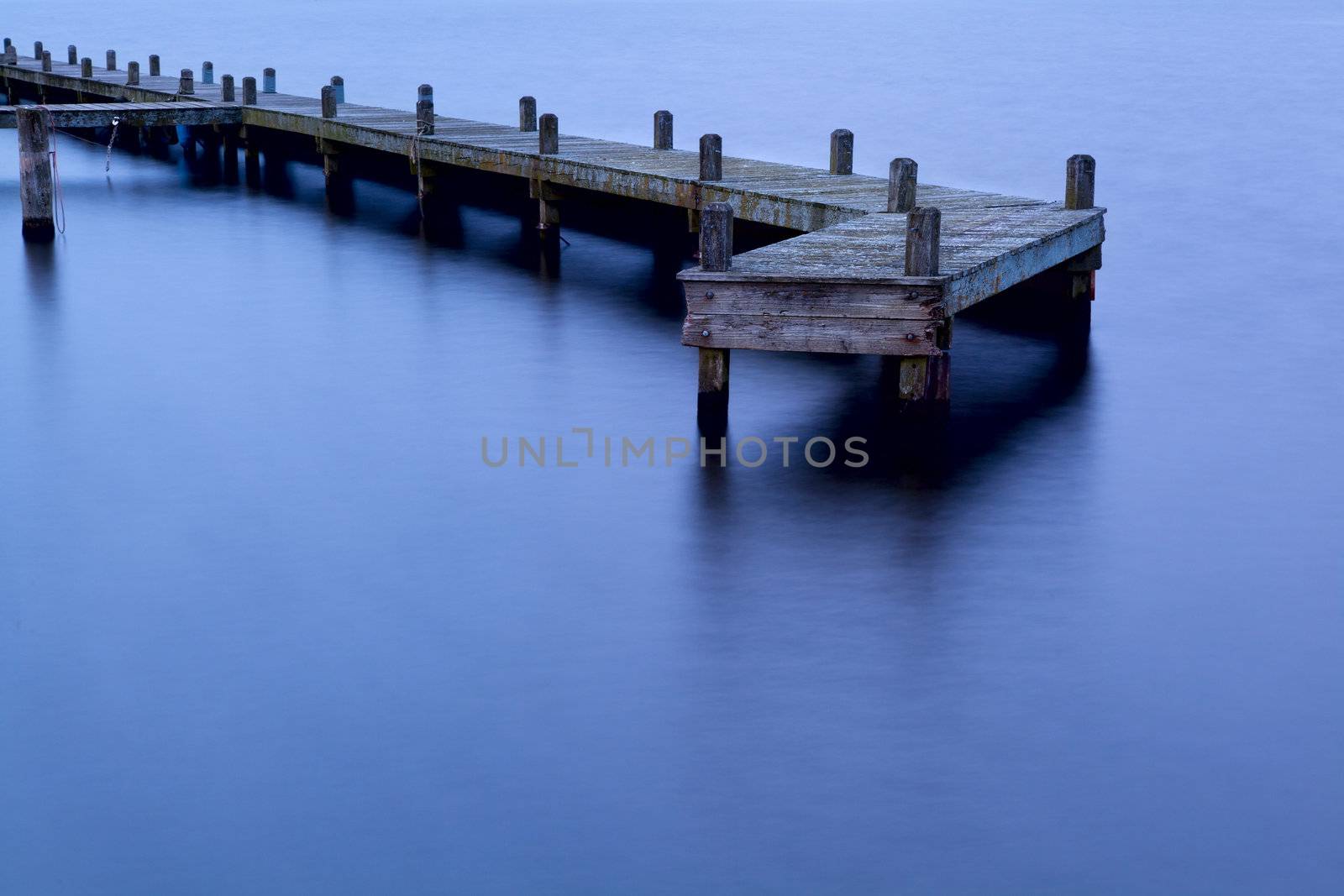 old wooden pier in water at sunset in Groningen, Netherlands