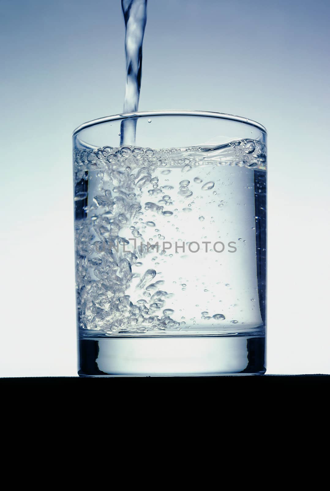 Water pouring into glass by Baltus