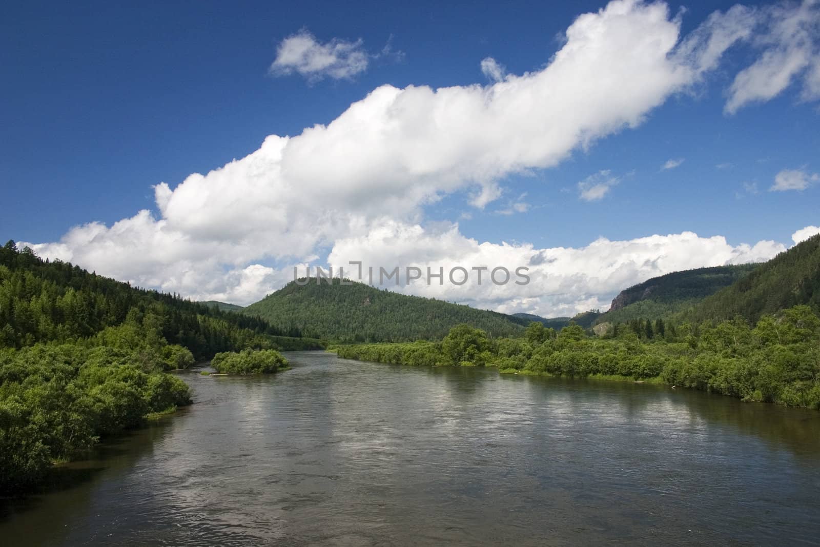 Summer. A river landscape with clouds.