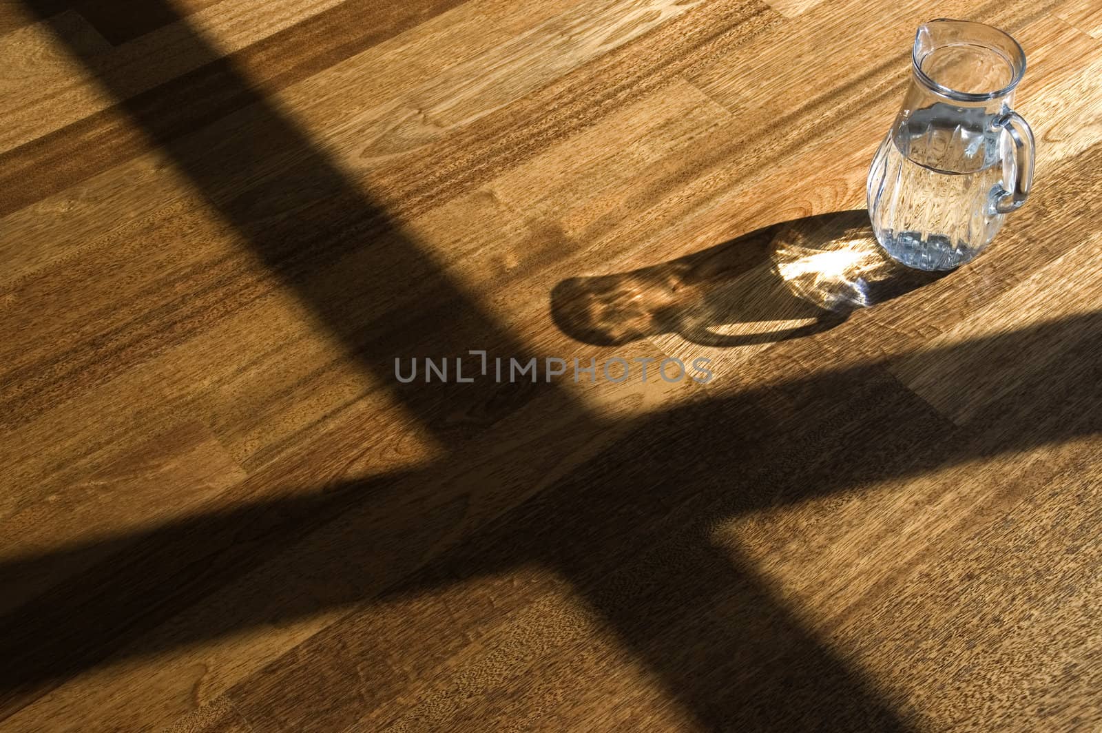 Decanter with water on a wooden floor.