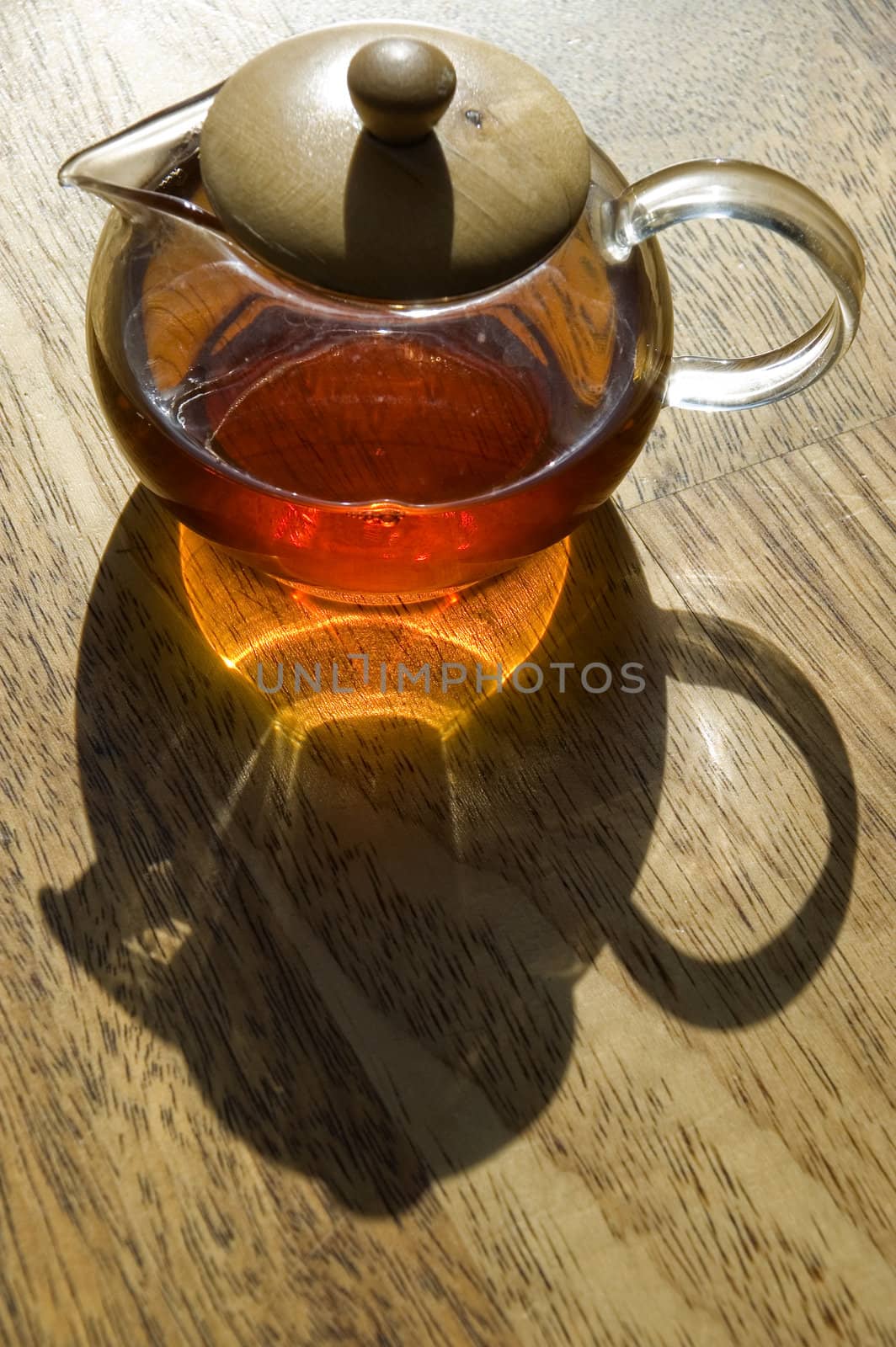 Transparent cup of tea on a wooden floor.

