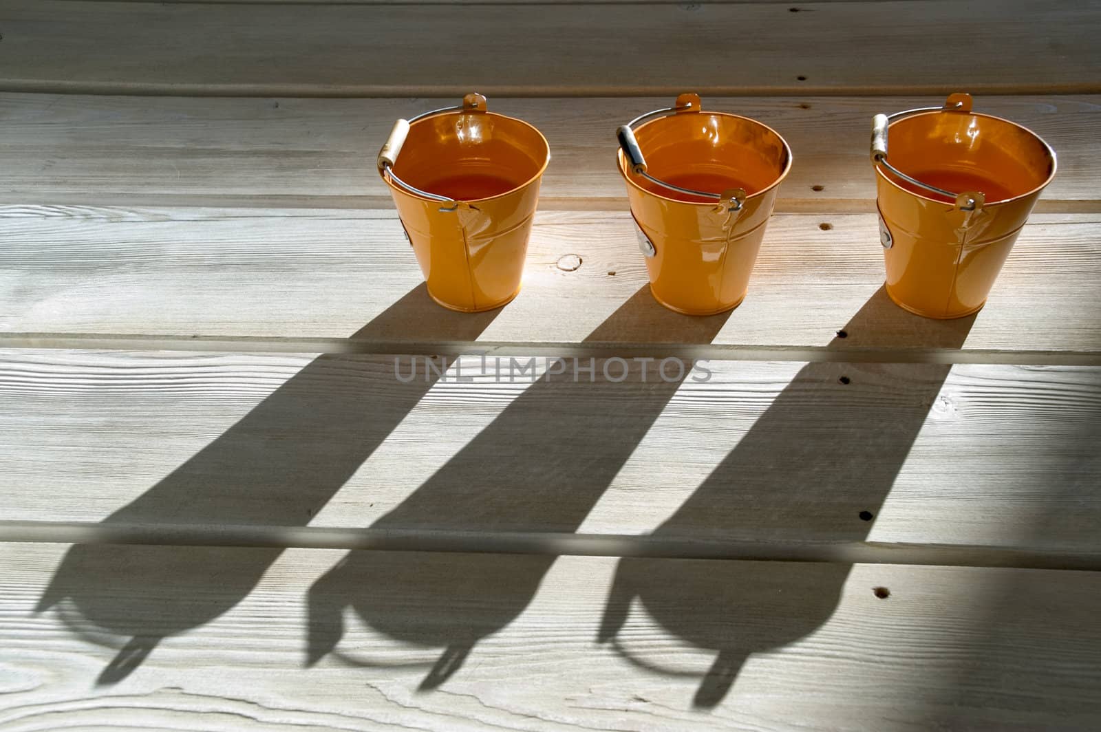 Orange utensils, shadow on a floor.