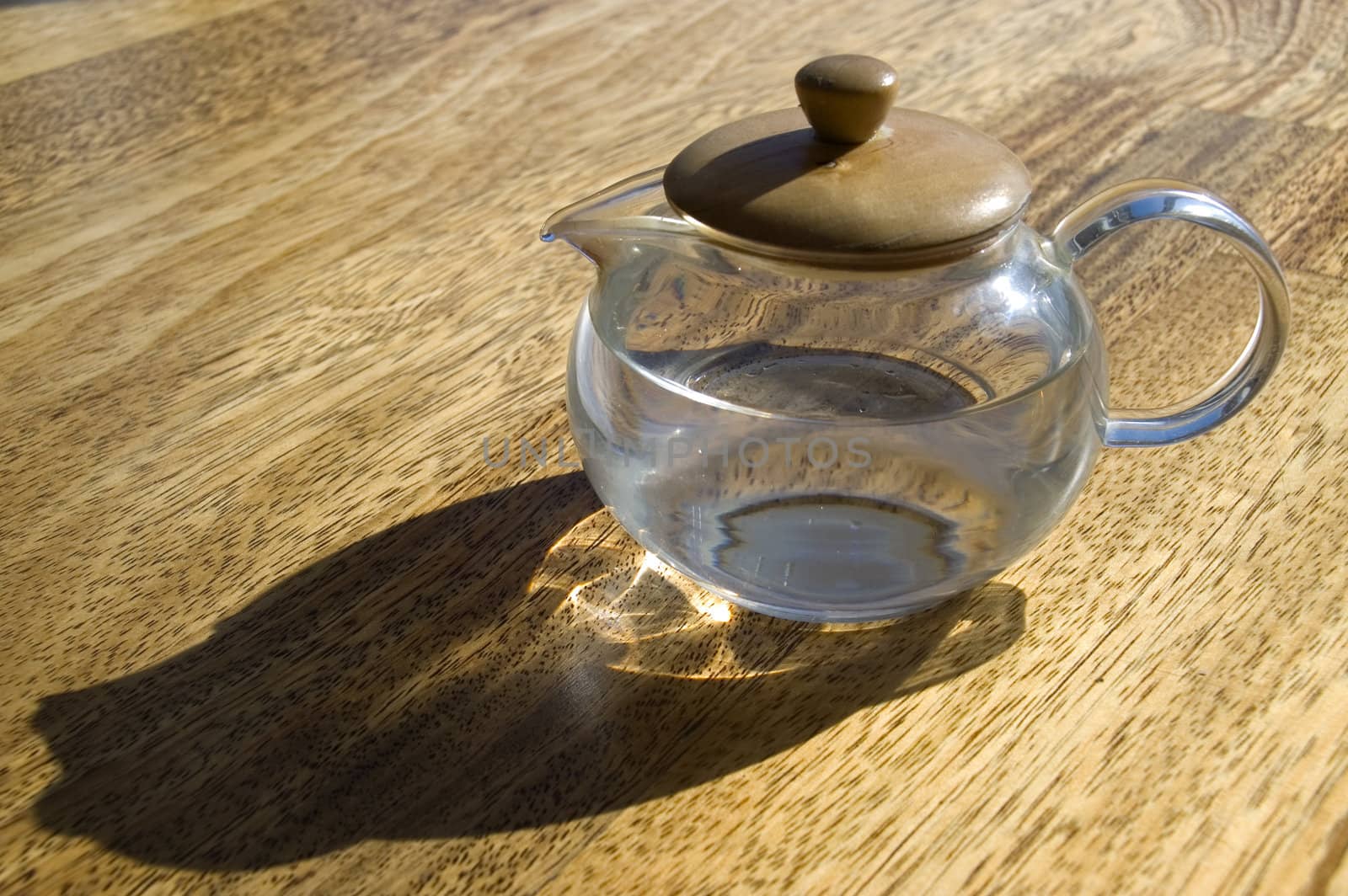Transparent cup with water on a wooden floor.