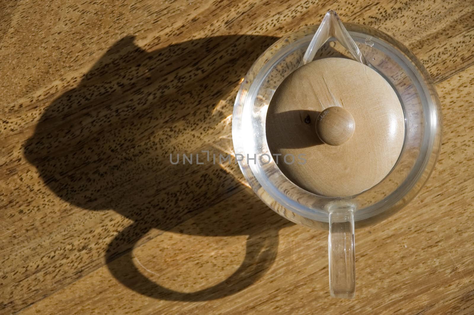 Transparent cup with water on a wooden floor.