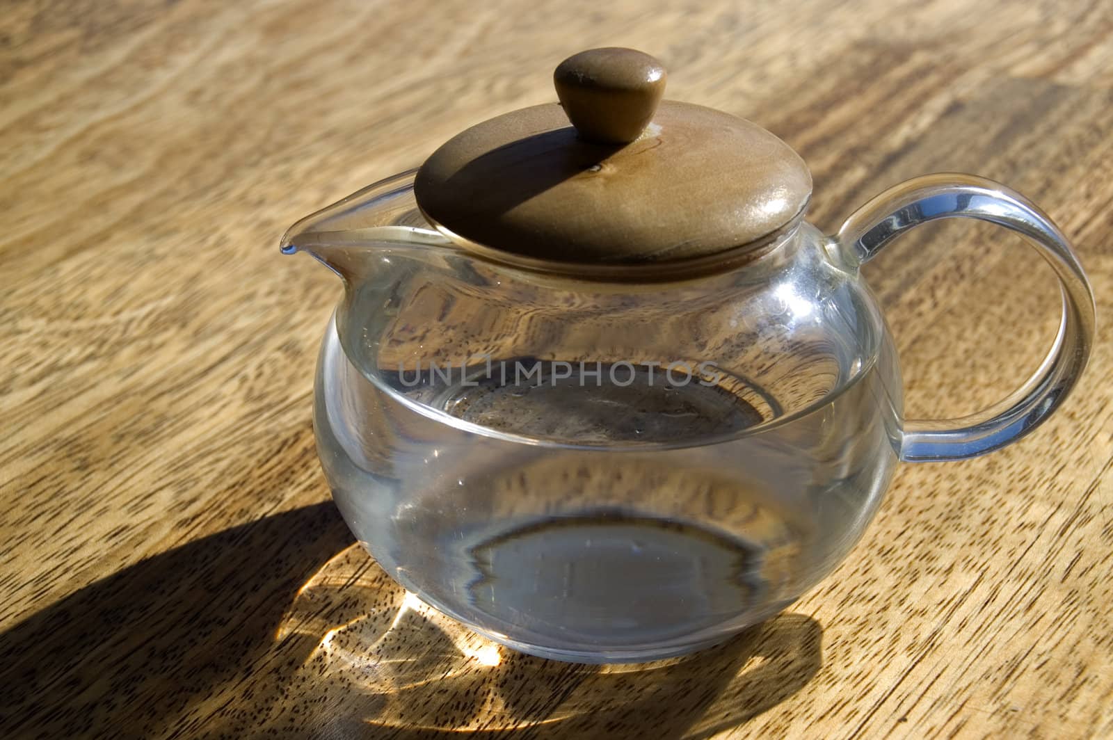 Transparent cup with water on a wooden floor.