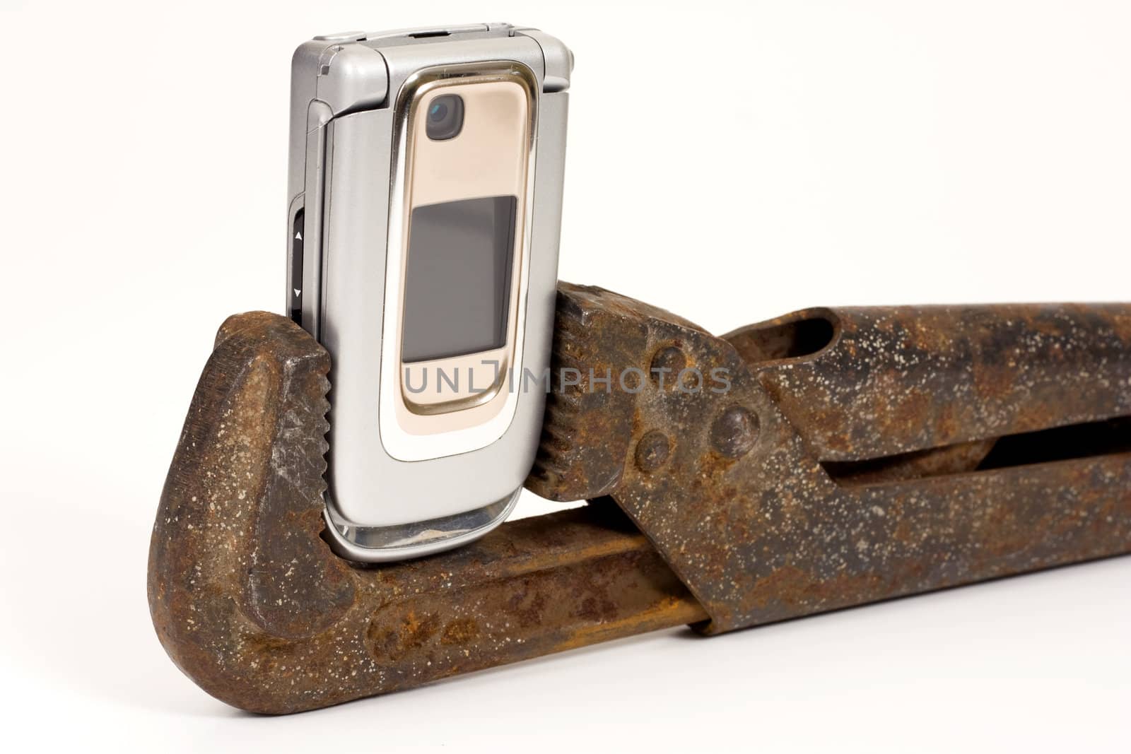 Old rusty spanner and modern telephone.