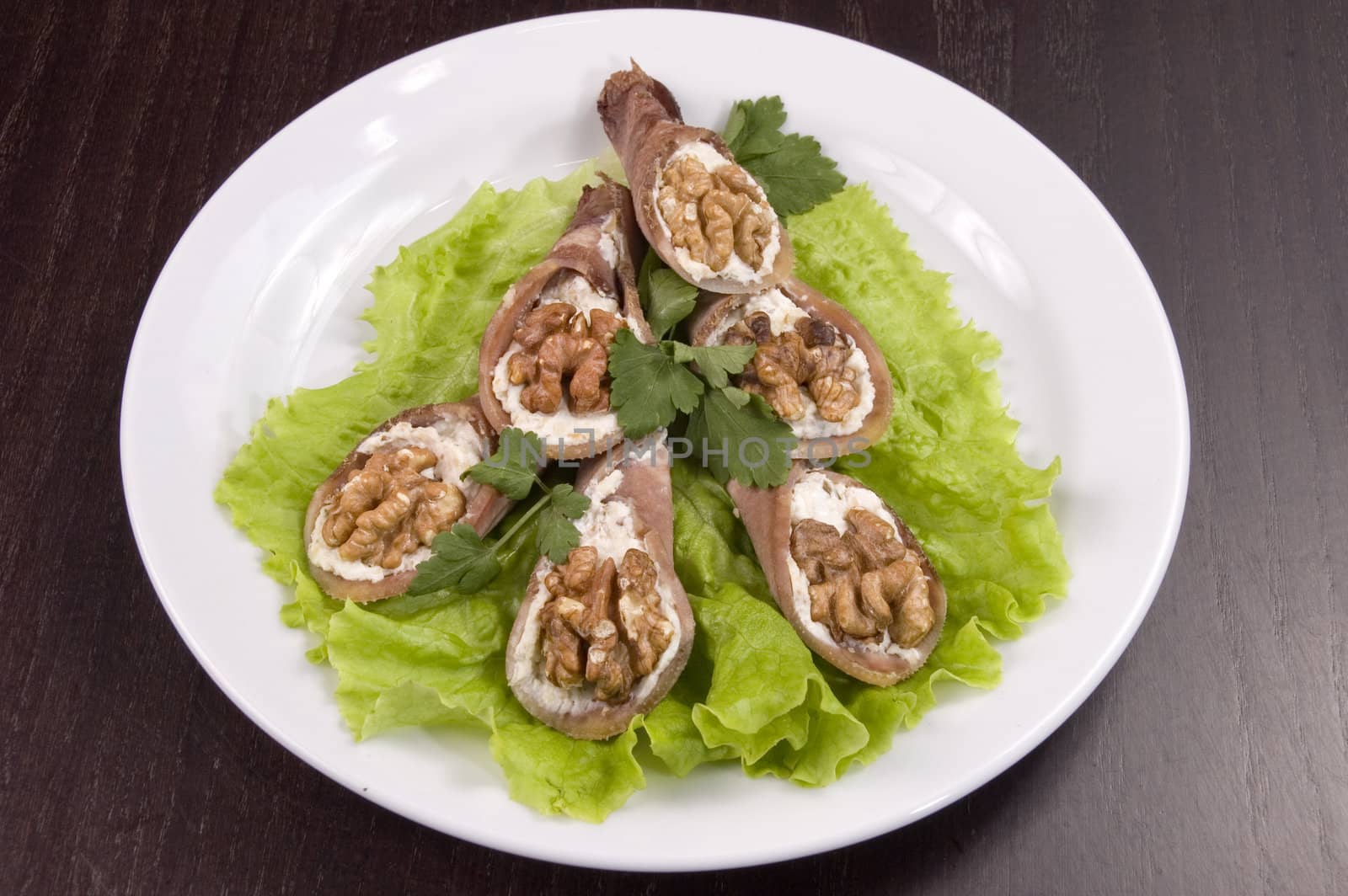 Tongue stuffed with a nut on a white plate.