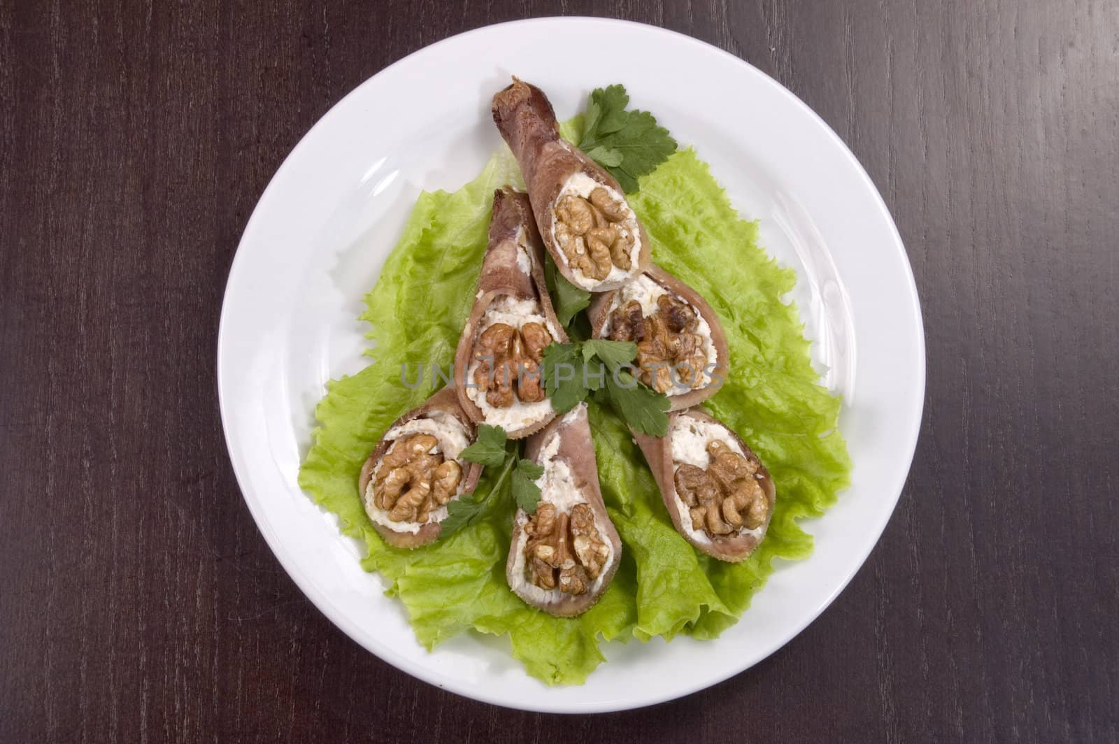 Tongue stuffed with a nut on a white plate.
