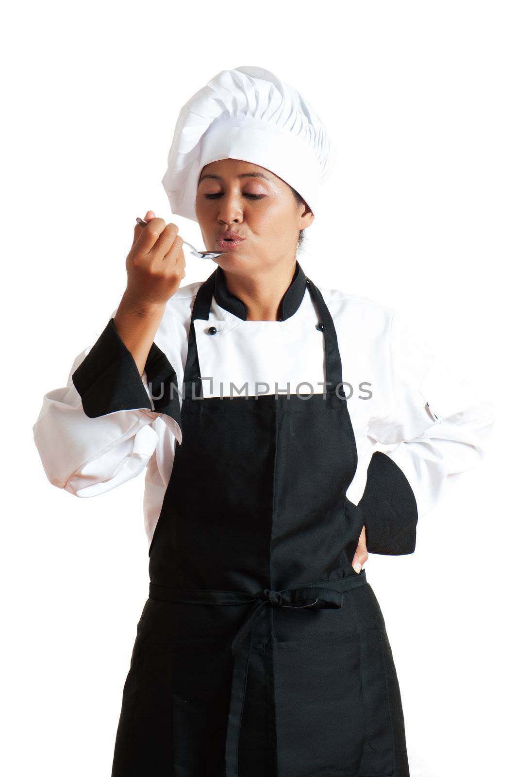 A asian woman as restaurant chef tasting something with a spoon in the hand on white background