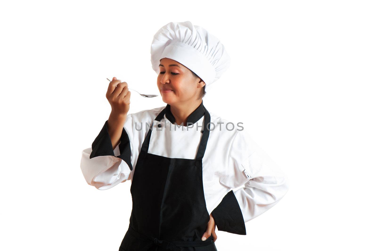 A asian woman as restaurant chef tasting something with a spoon in the hand on white background
