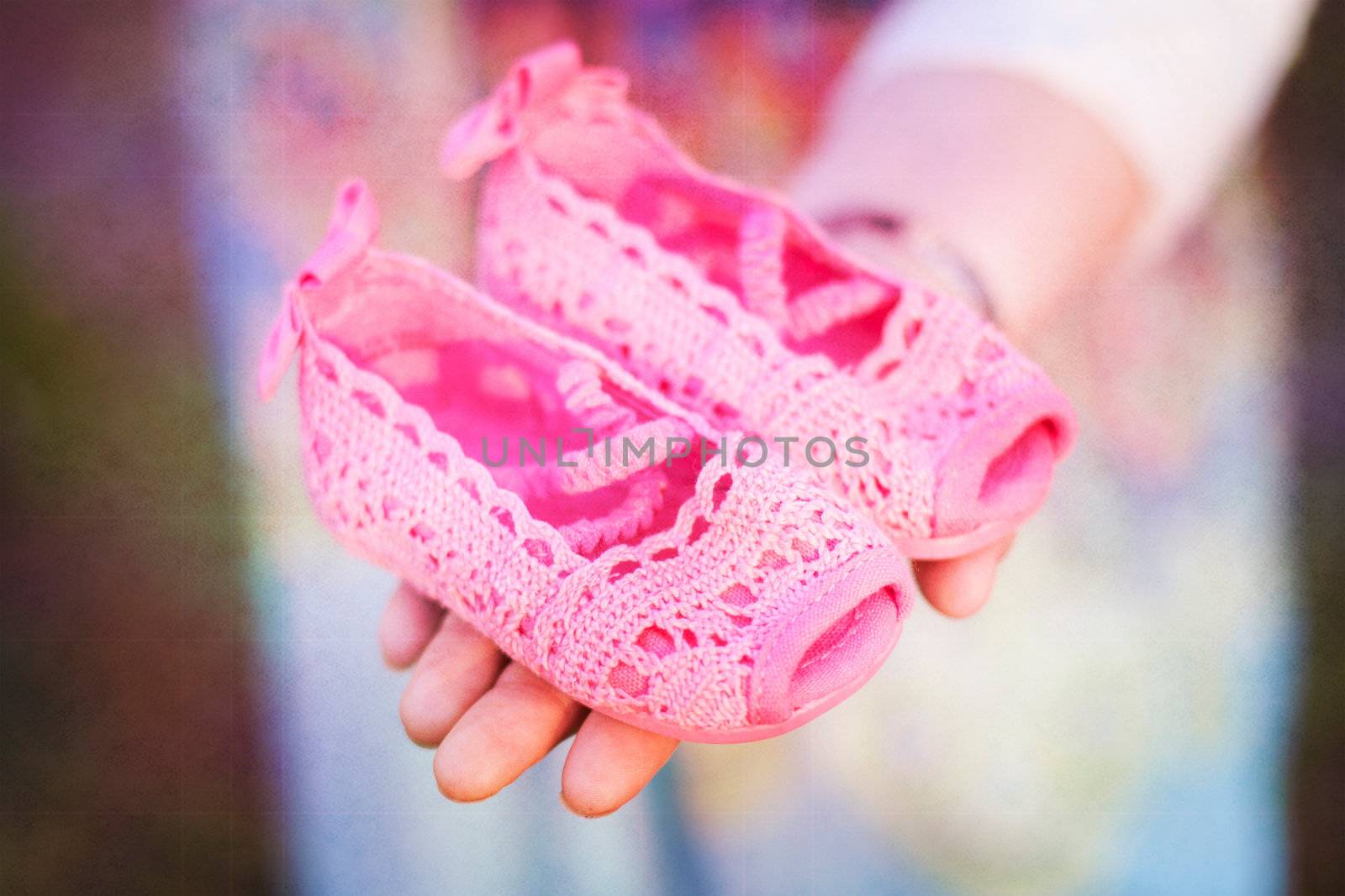 bright pink baby shoes in womans hand