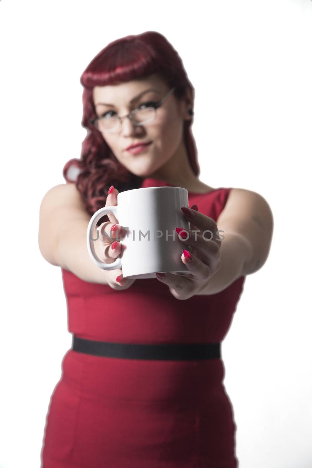 Coffee cup held up with out of focus red headed sexy business woman in the background. Isolated on white background