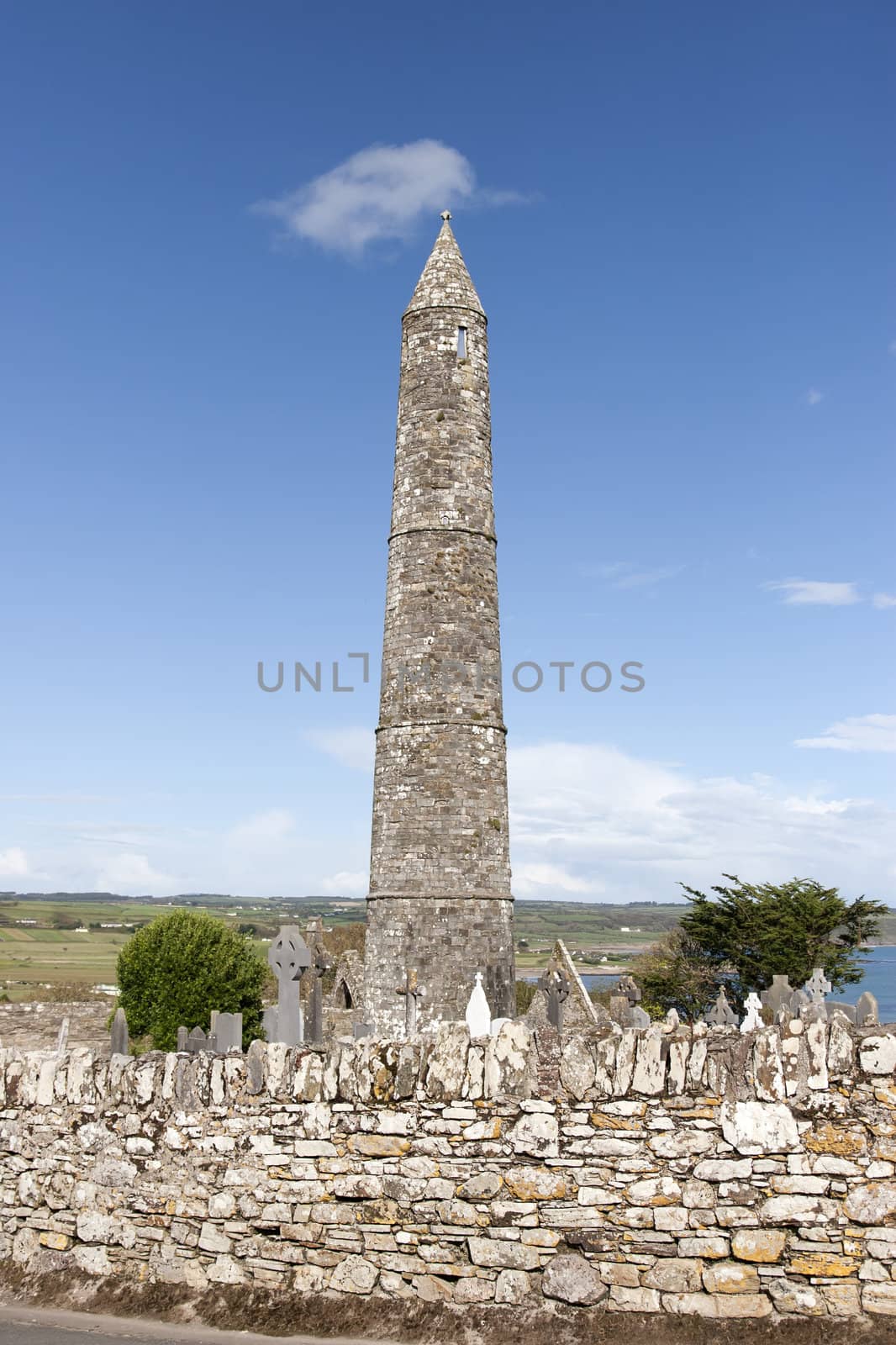 Ancient round tower and celtic graveyard with cathedral in Ardmore county Waterford, Ireland