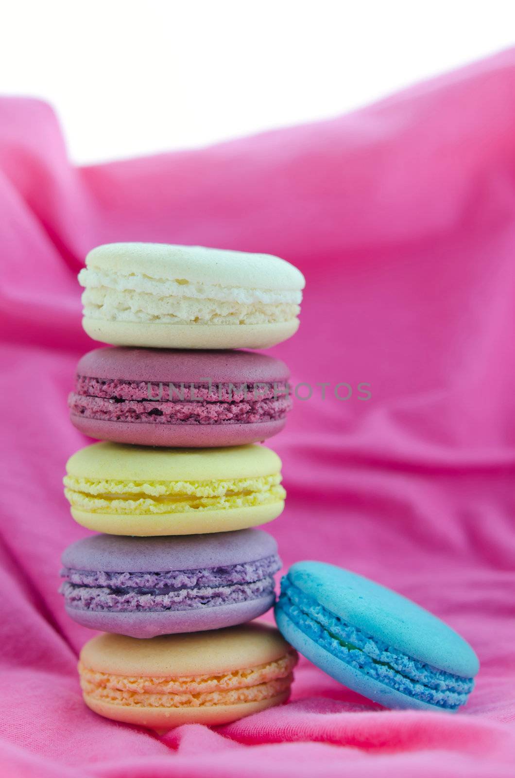  french macaroons  stack on  pink fabric over white background