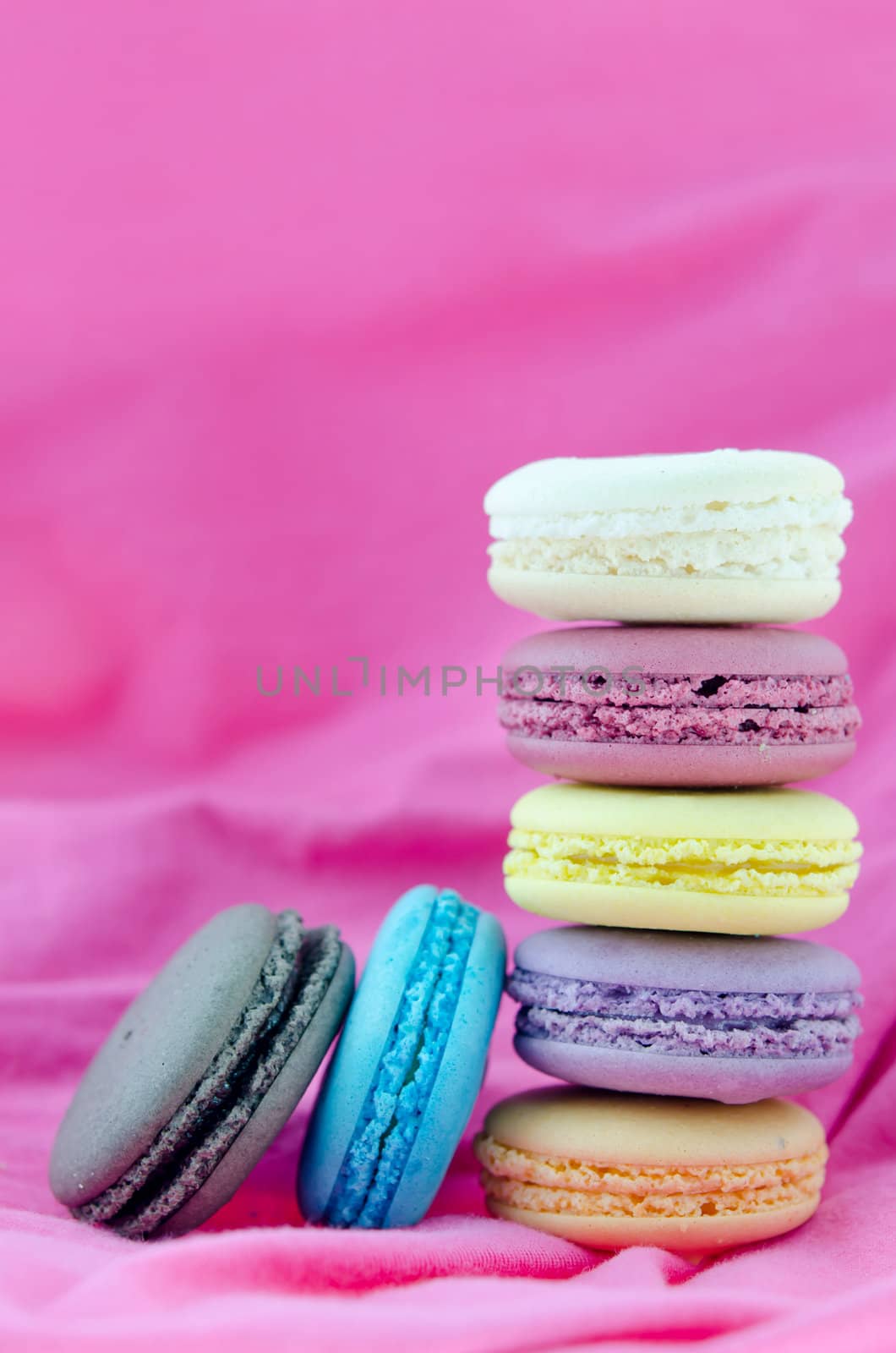 traditional colorful  french macaroons  stack on  pink fabric background