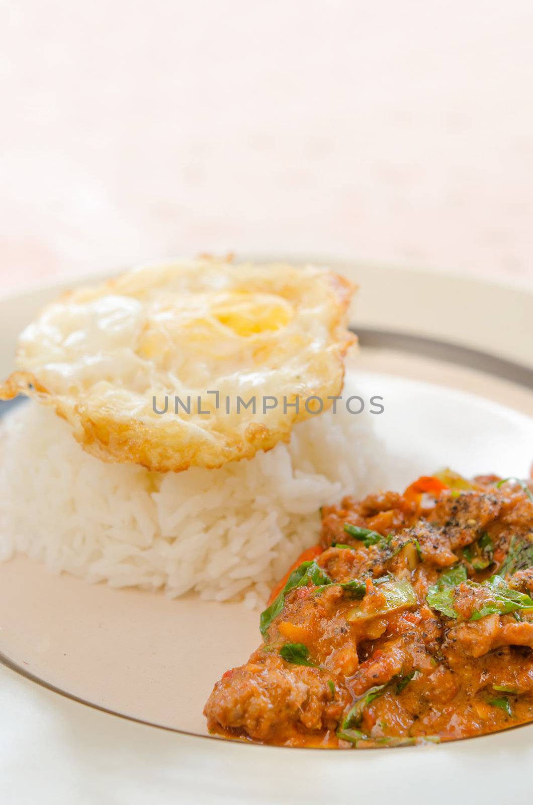 pork fried with chili pepper and curry sauce and  fried egg over rice on dish