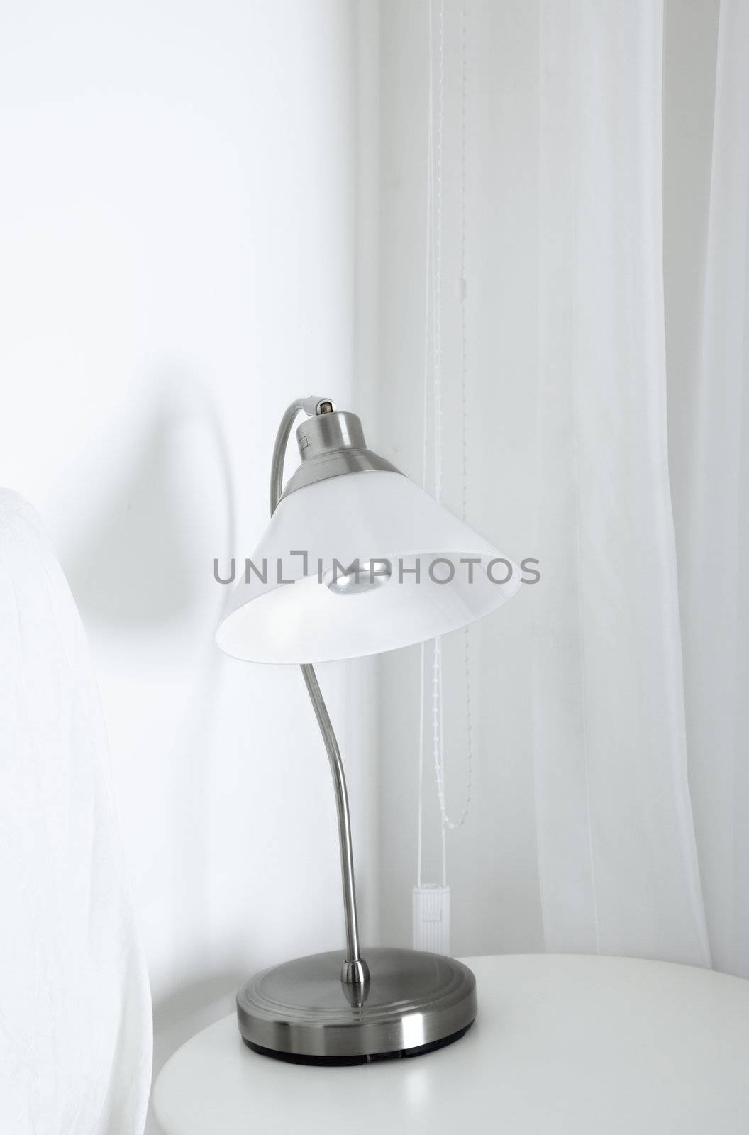 White table lamp in a white interior with wite curtain