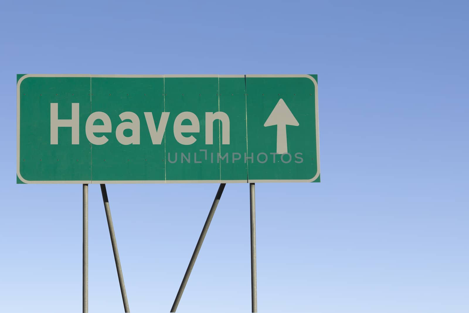 Green road sign with a blue sky gradient background.