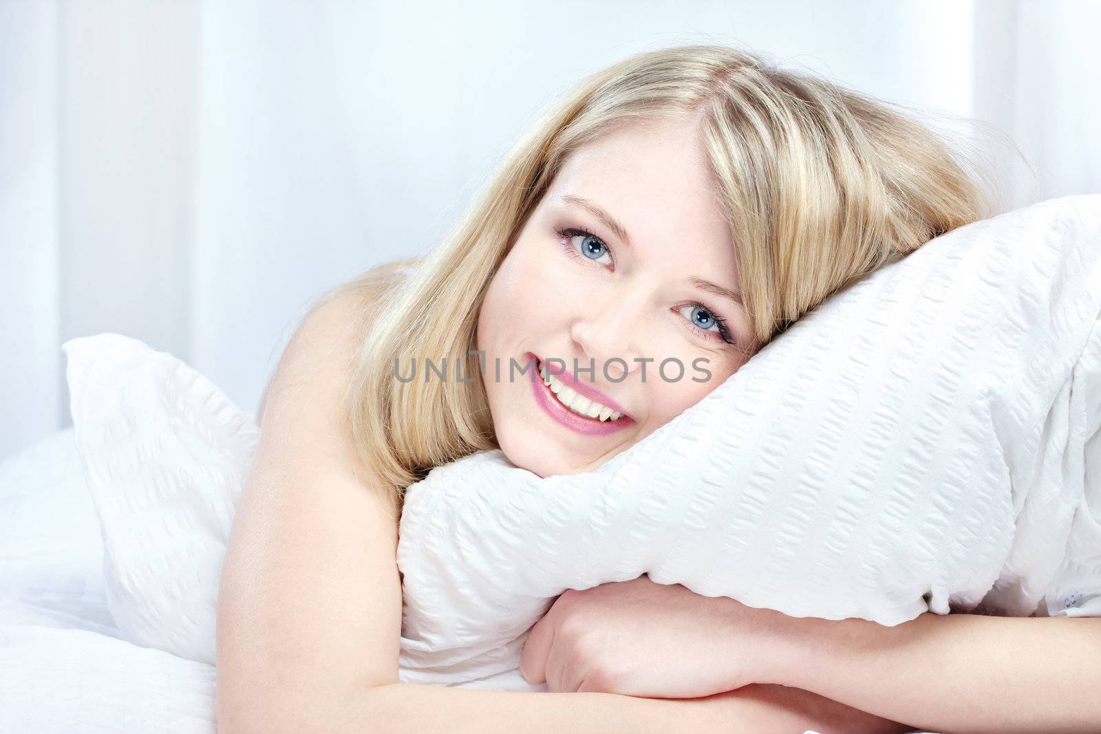 Portrait of beautiful smiling woman on bed at bedroom