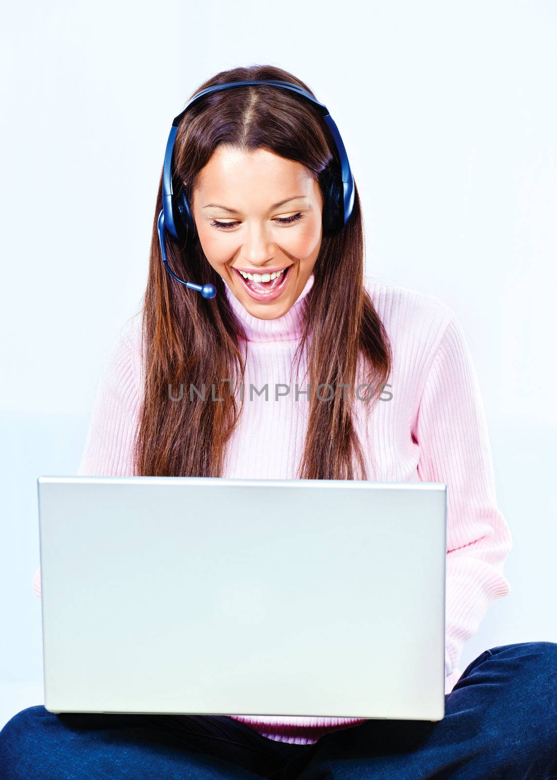 Happy young woman with headphones and  laptop at home