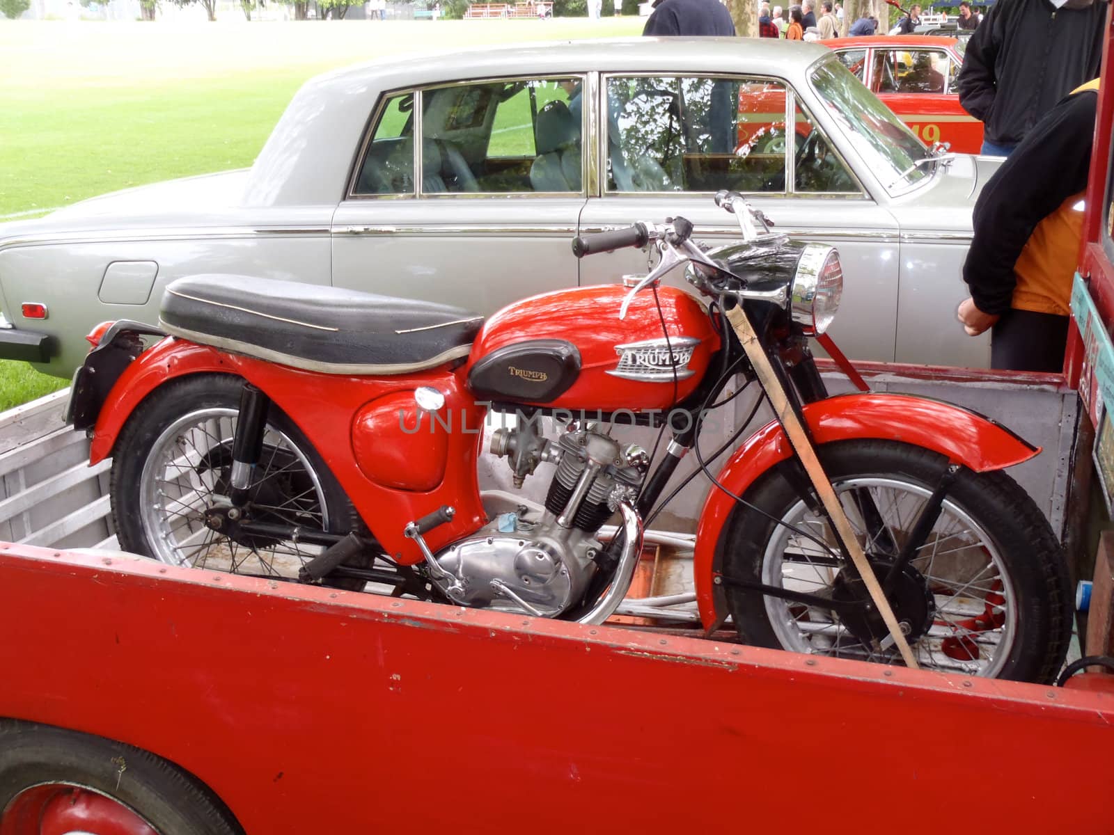 Old red triumph in back of pickup